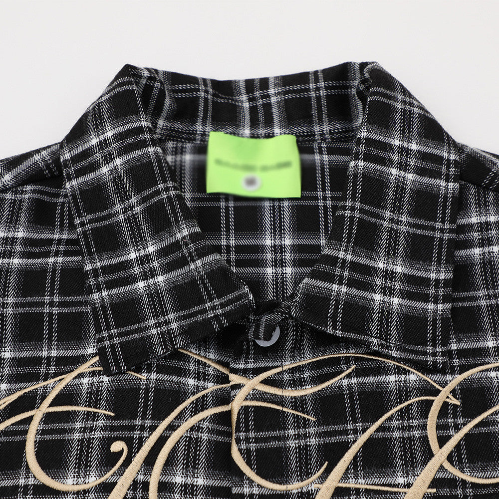 Loose short-sleeve black and white checkered shirt with beige script embroidery.