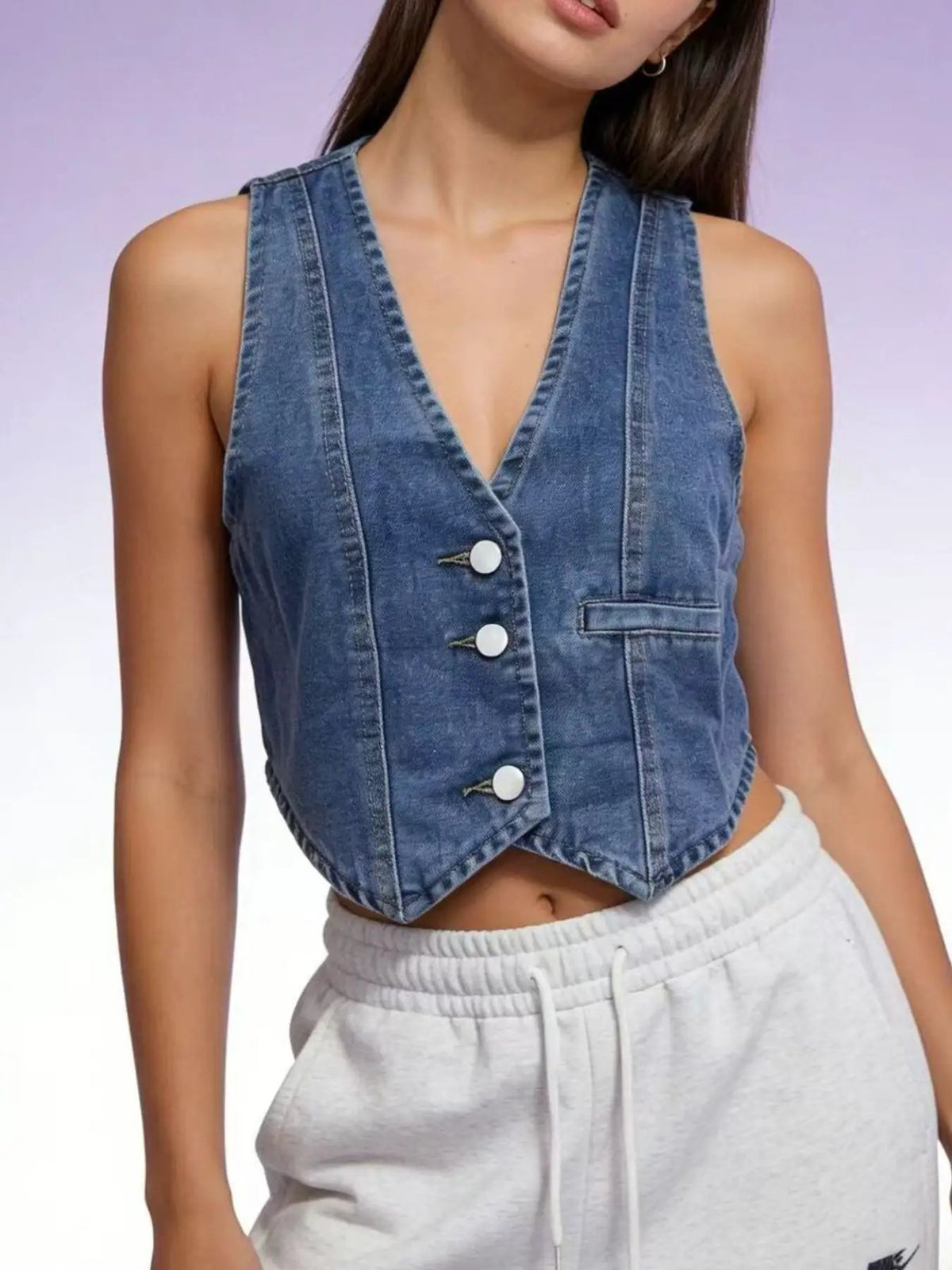 Unlined button-down cropped denim vest in blue with metal buttons and a front pocket