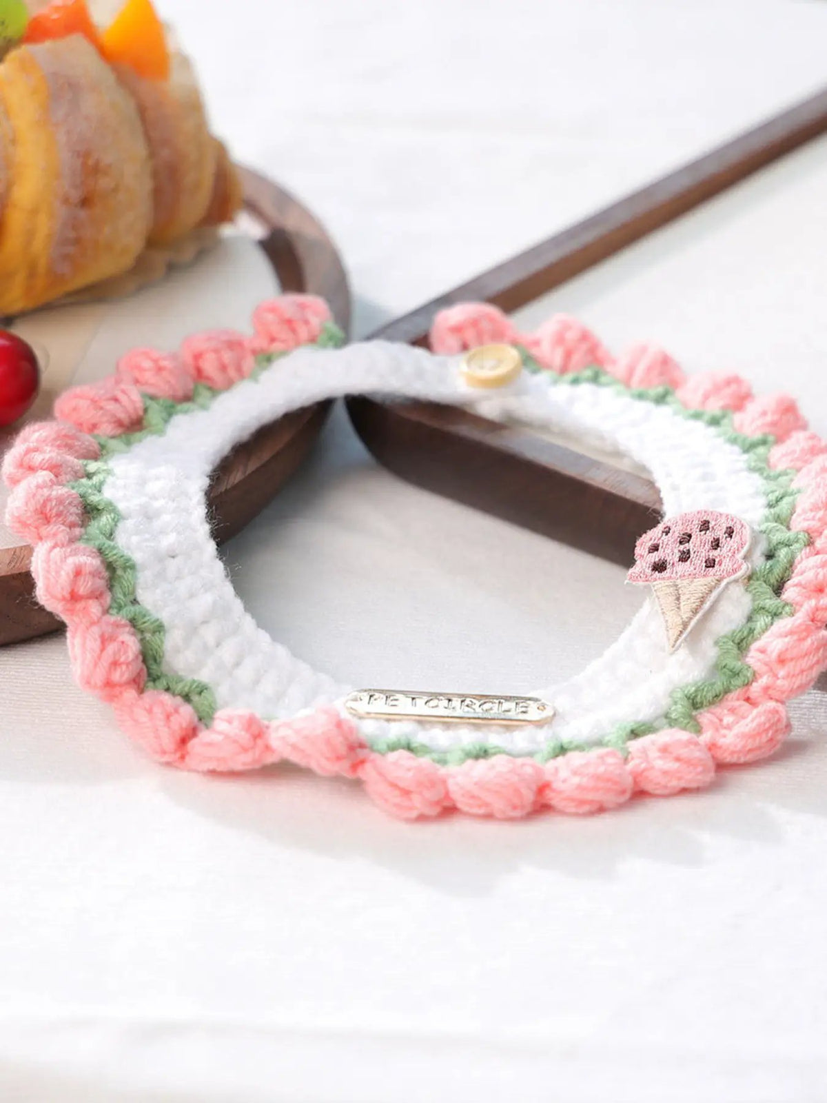 Contrast pet scarf collar with white knit center, pink crochet border, green leaves, and ice cream cone patch
