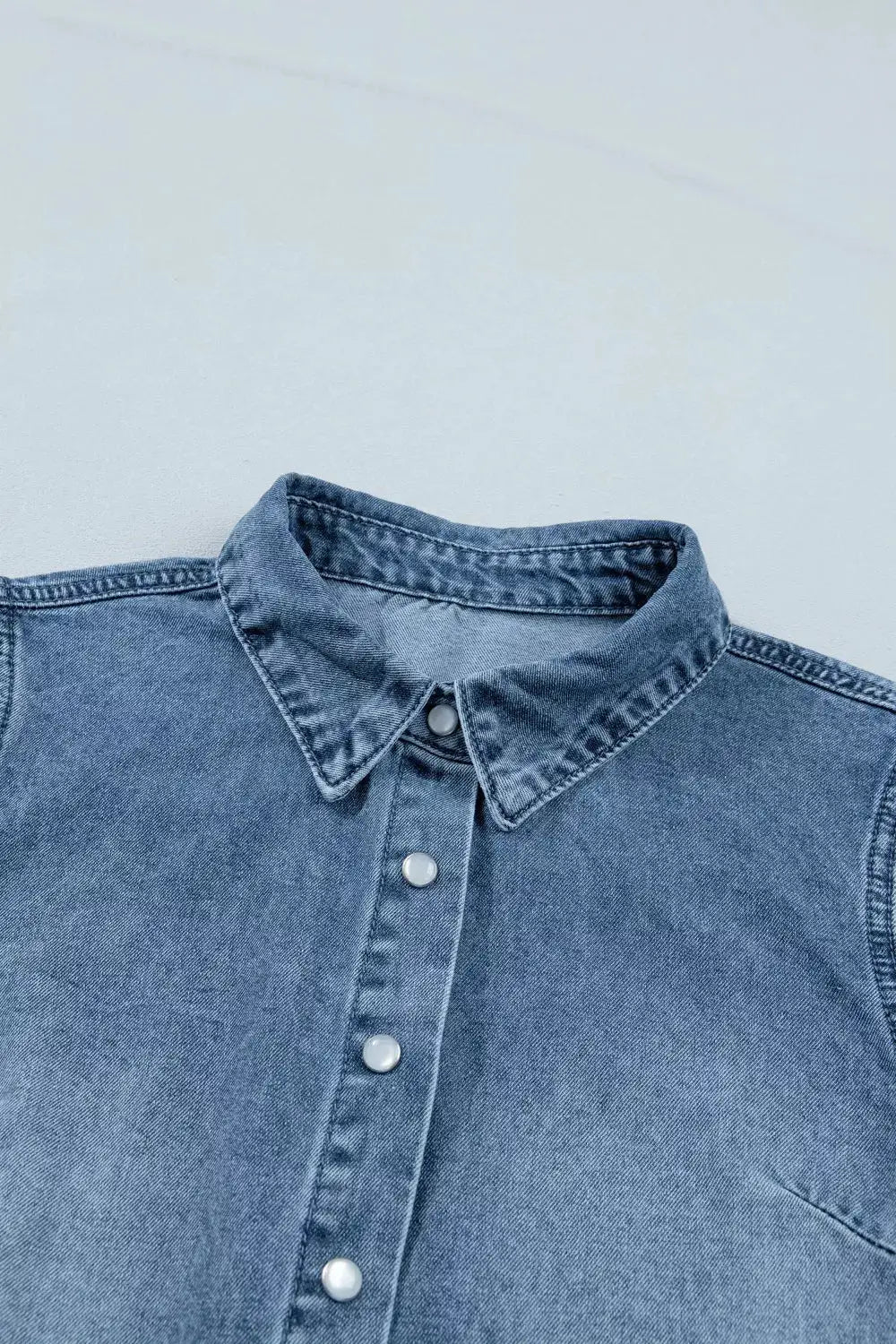 Girls lightweight denim shirt with snap buttons and collar in blue.