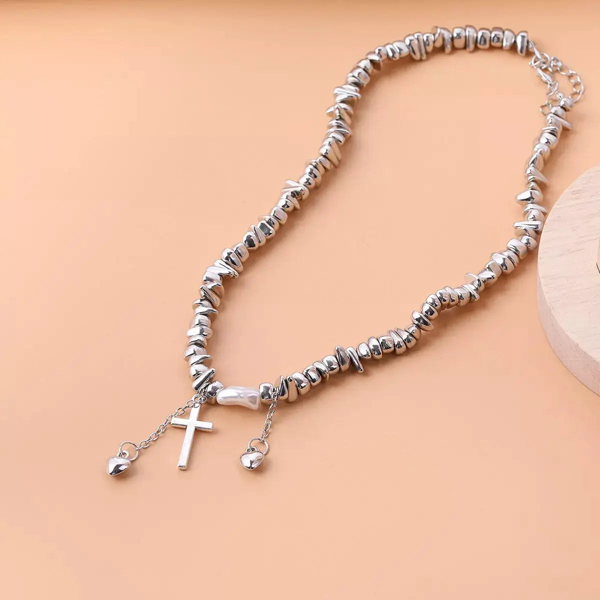Chunky chain cross pendant necklace in silver-tone metal with dangling heart charms