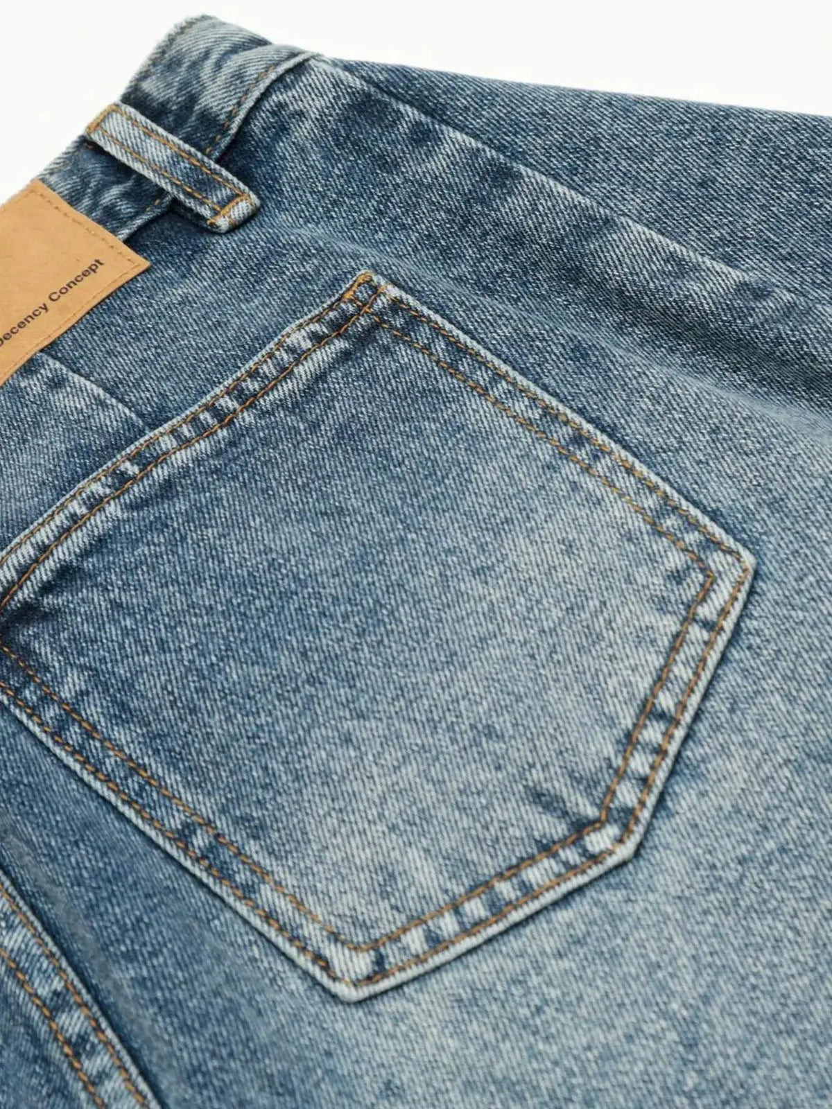 Men's washed denim shorts pocket detail in blue fabric with orange stitching