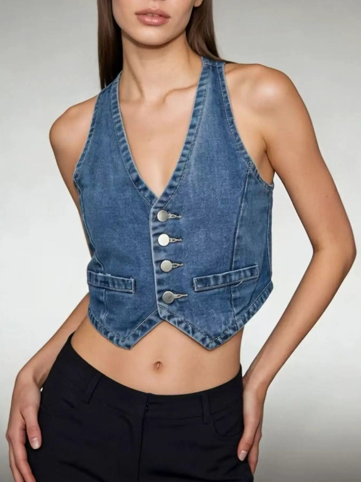 Denim vest for layering; classic button-down front in blue cotton-blend with silver snaps and waist pockets.
