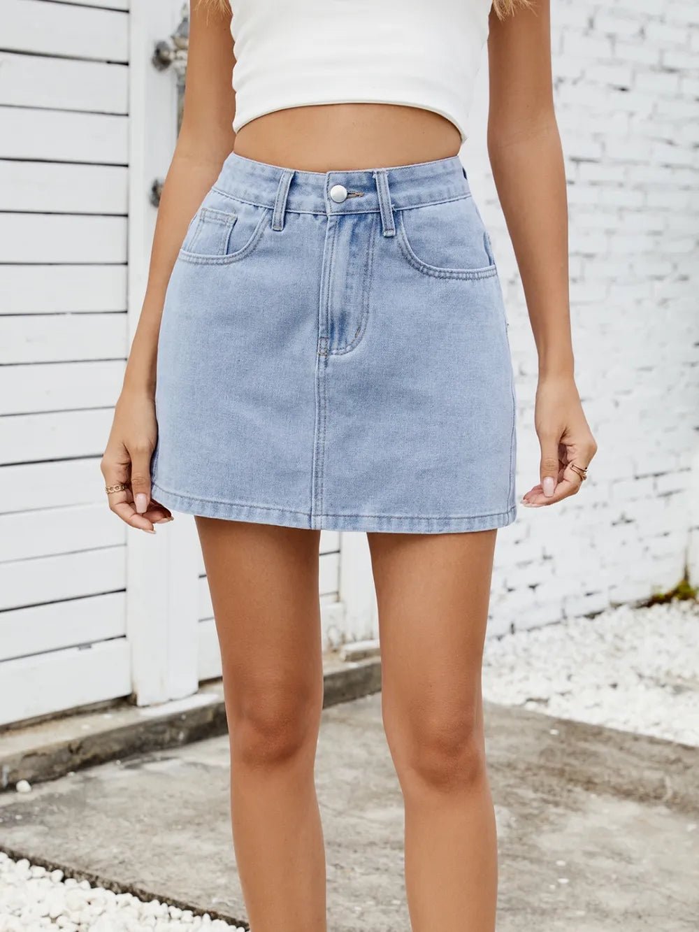 Solid mini denim skirt by eprolo, light blue denim with front pockets and belt loops.