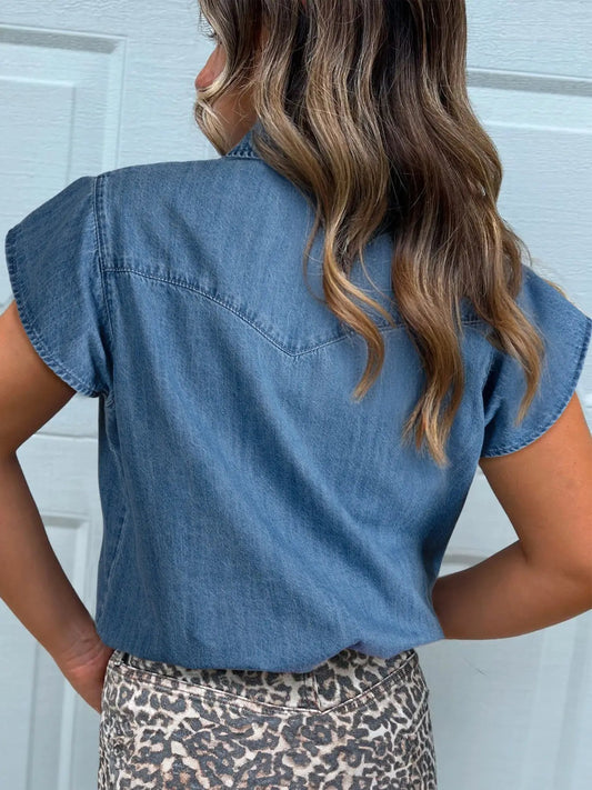 Women's denim button-up blouse with ruffled short sleeves; light blue, back view