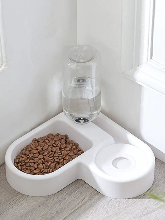 Automatic water-refilling pet bowls in white plastic with clear water bottle; kibble bowl on left.