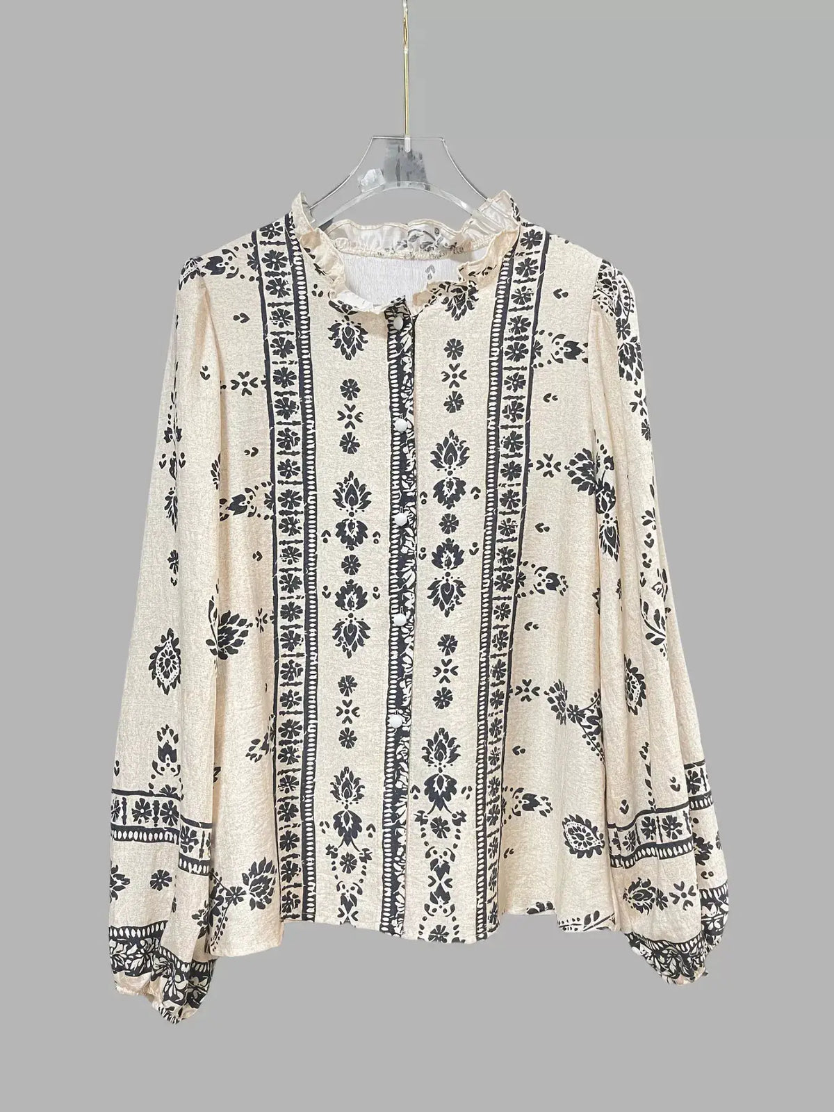 Vintage print long sleeve cream shirt with black floral vertical stripes and a ruffled collar.