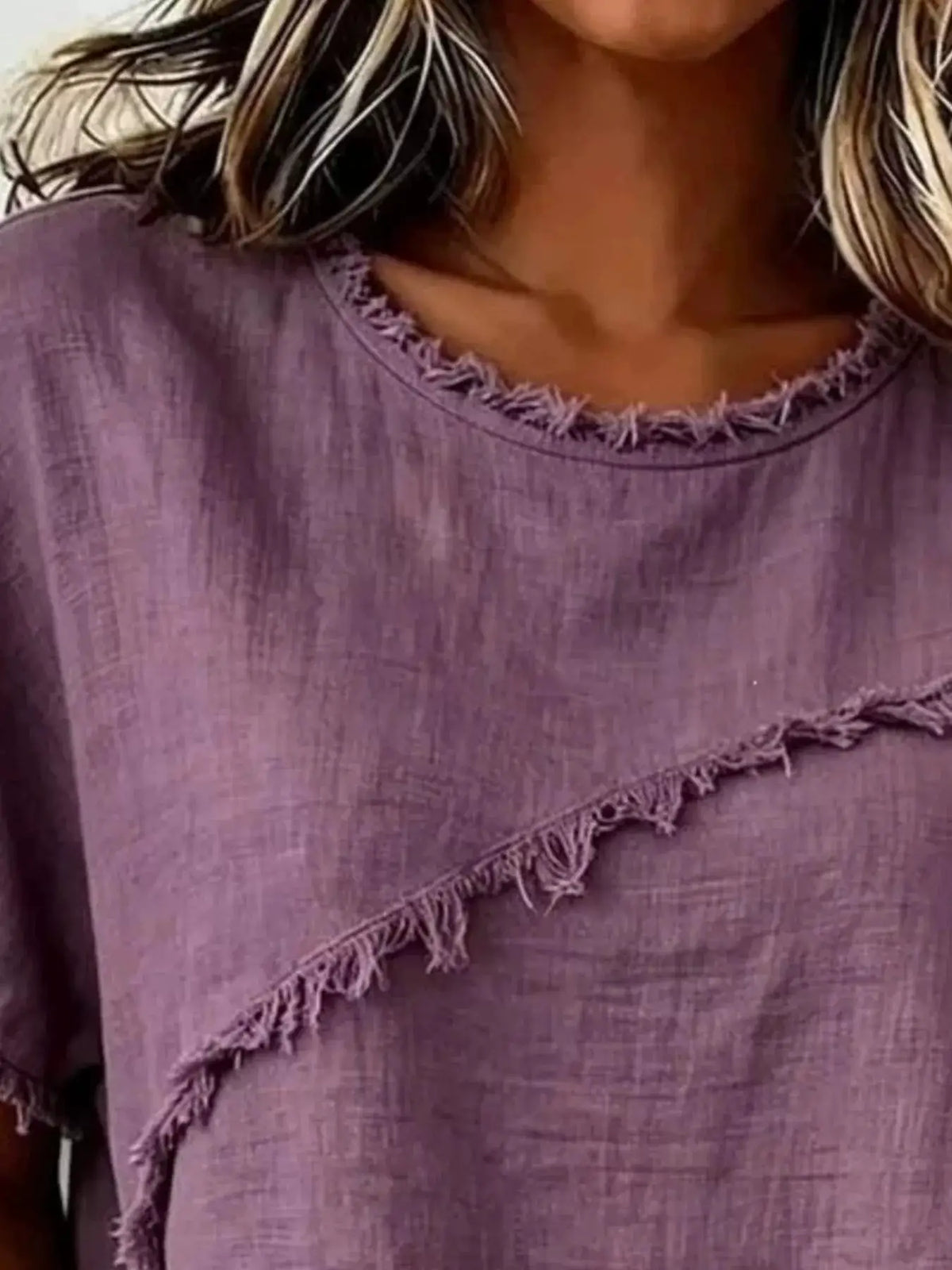 Plus-size lavender short-sleeve top with frayed neckline trim and diagonal fringe across the bodice.