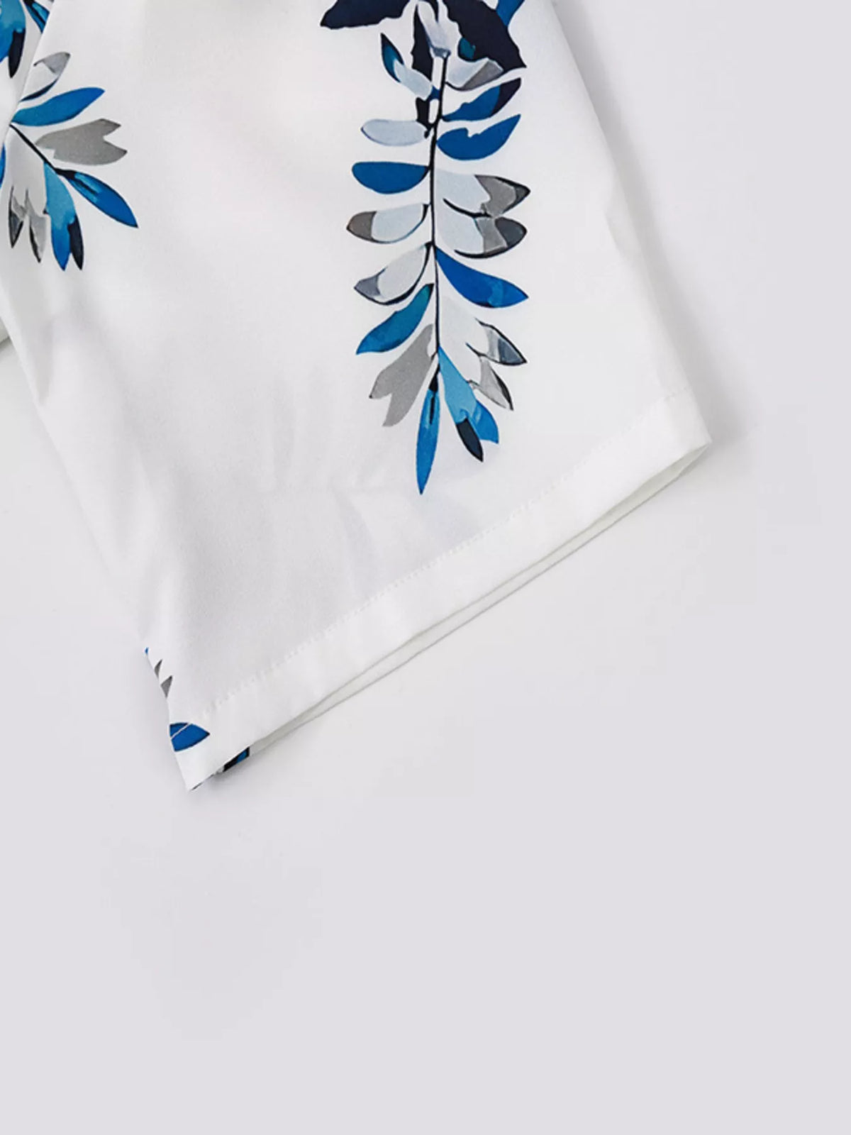 Men's plus-size tropical print short-sleeve shirt and shorts set, white fabric with blue and gray leaf pattern.