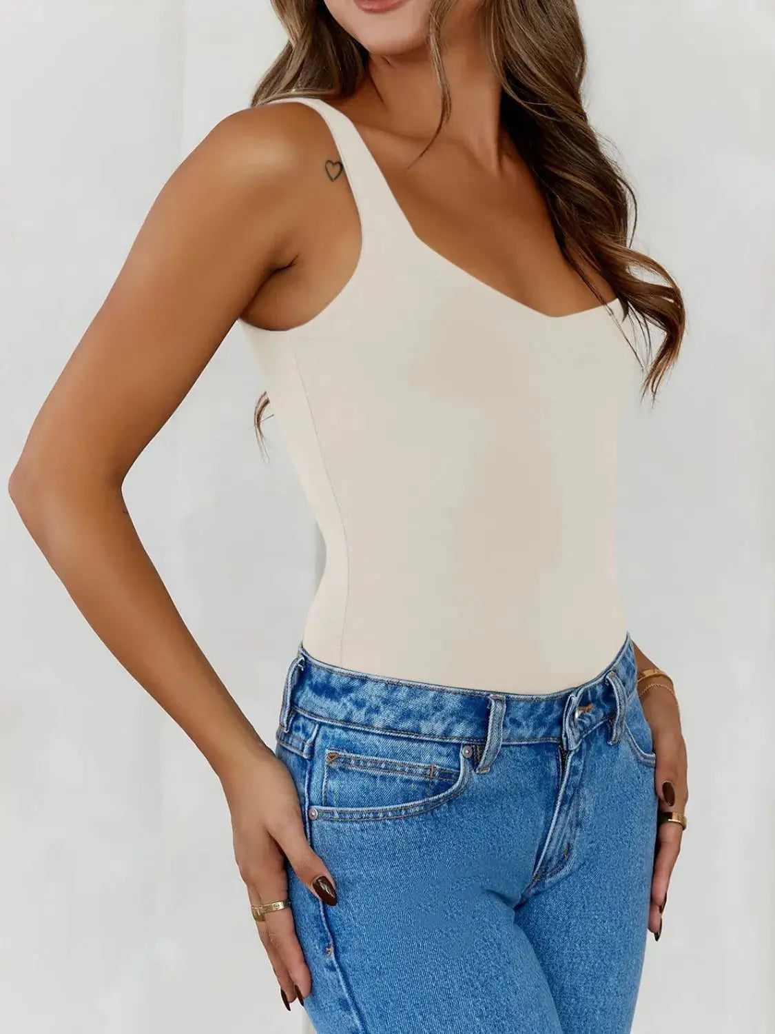 Solid color wide-strap cami top in ivory worn with blue denim jeans