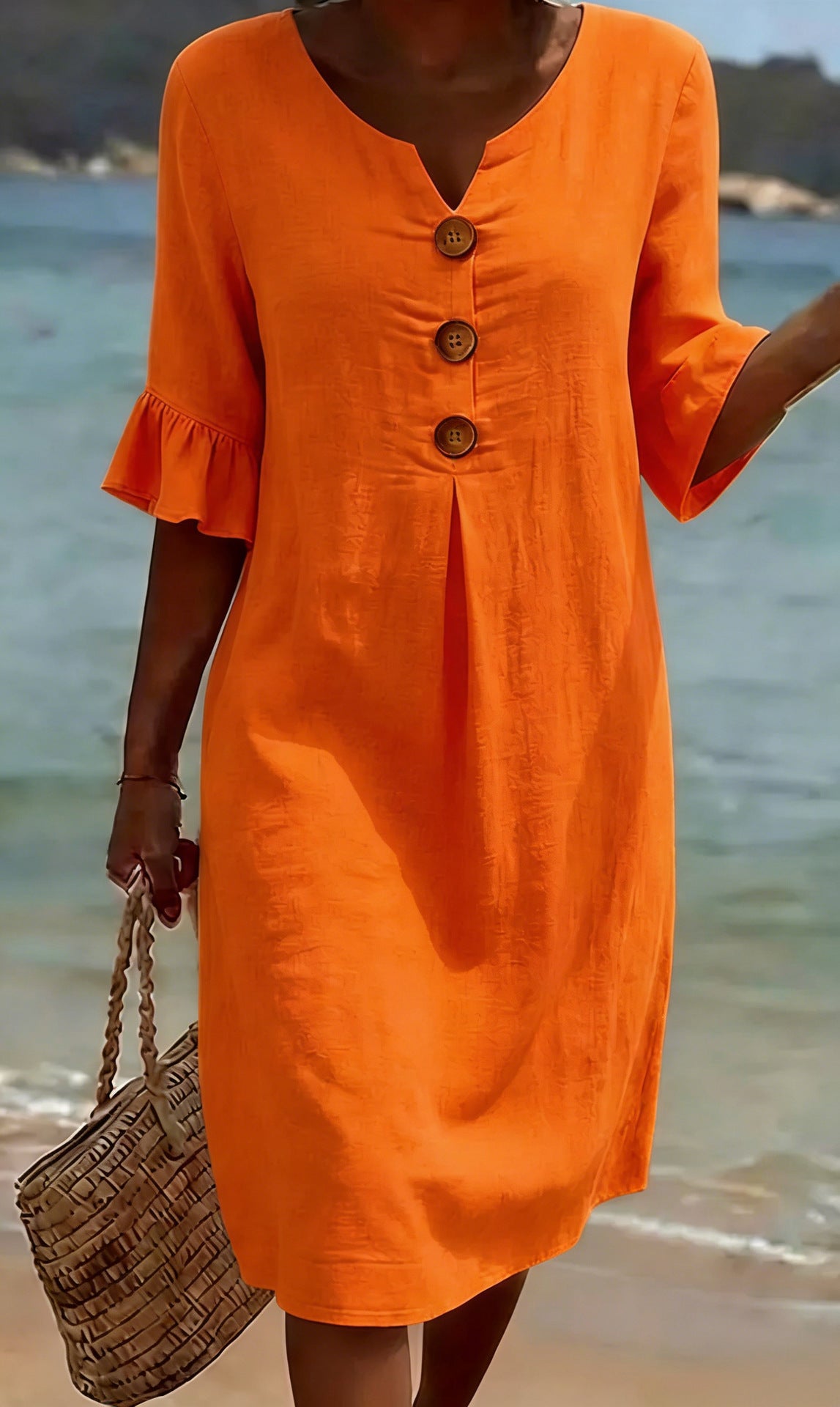 Orange cotton dress with front button placket, knee-length, and ruffled sleeves.