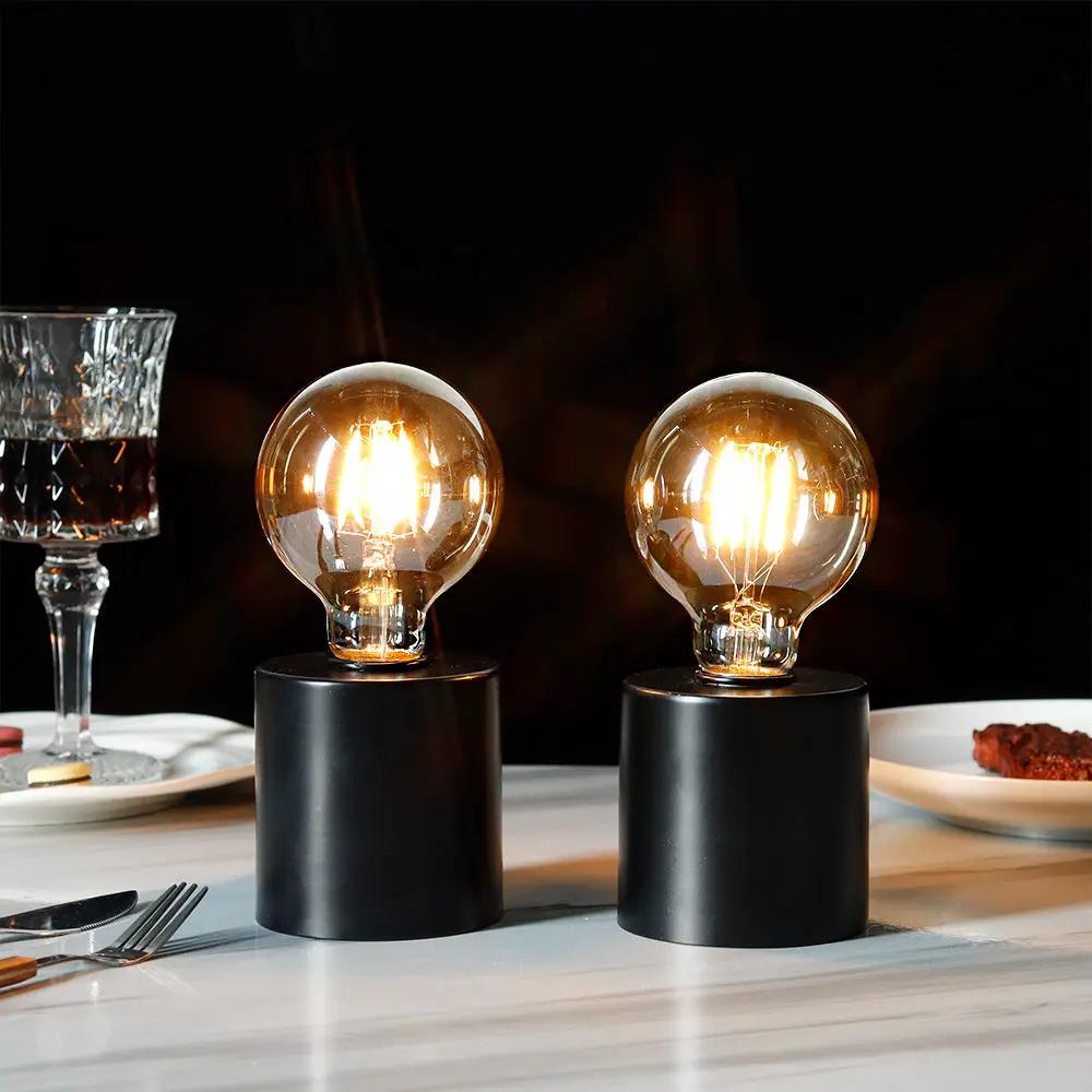 7-inch tall black battery-powered table lamps (set of 2) by JHY DESIGN with clear glass bulbs on black bases