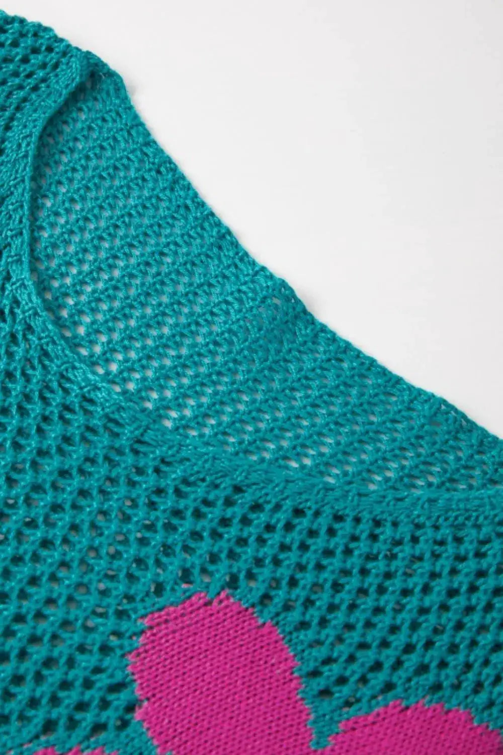 Lightweight openwork floral knit cover up in teal with pink floral motif; round neck.