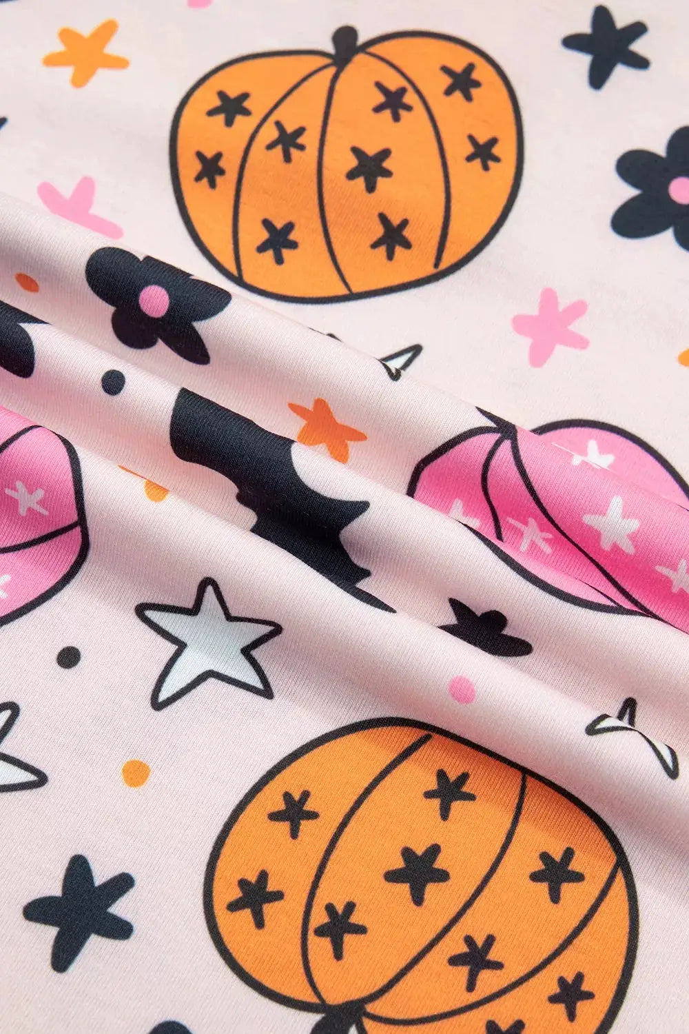 Halloween pumpkin print long sleeve lounge set on pink fabric with orange pumpkins and stars