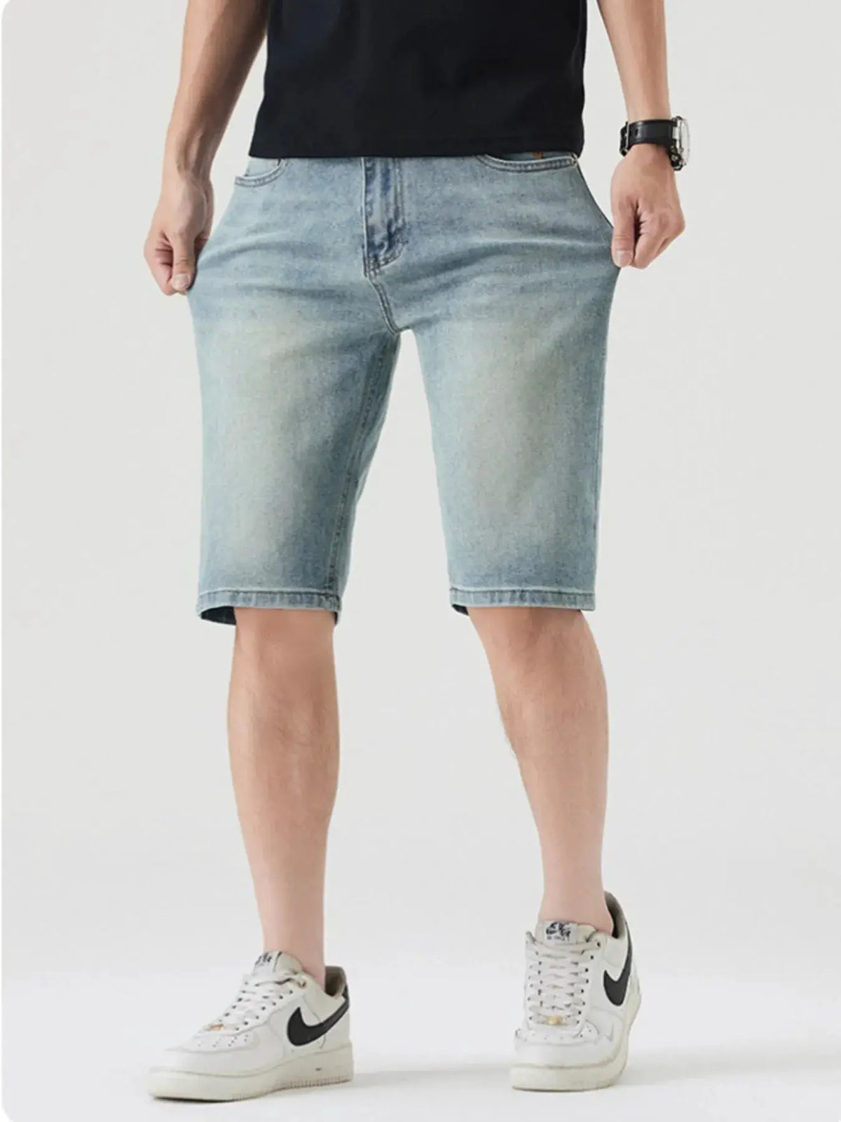 Men's casual stretch cotton denim shorts in light wash with large front pockets, knee-length