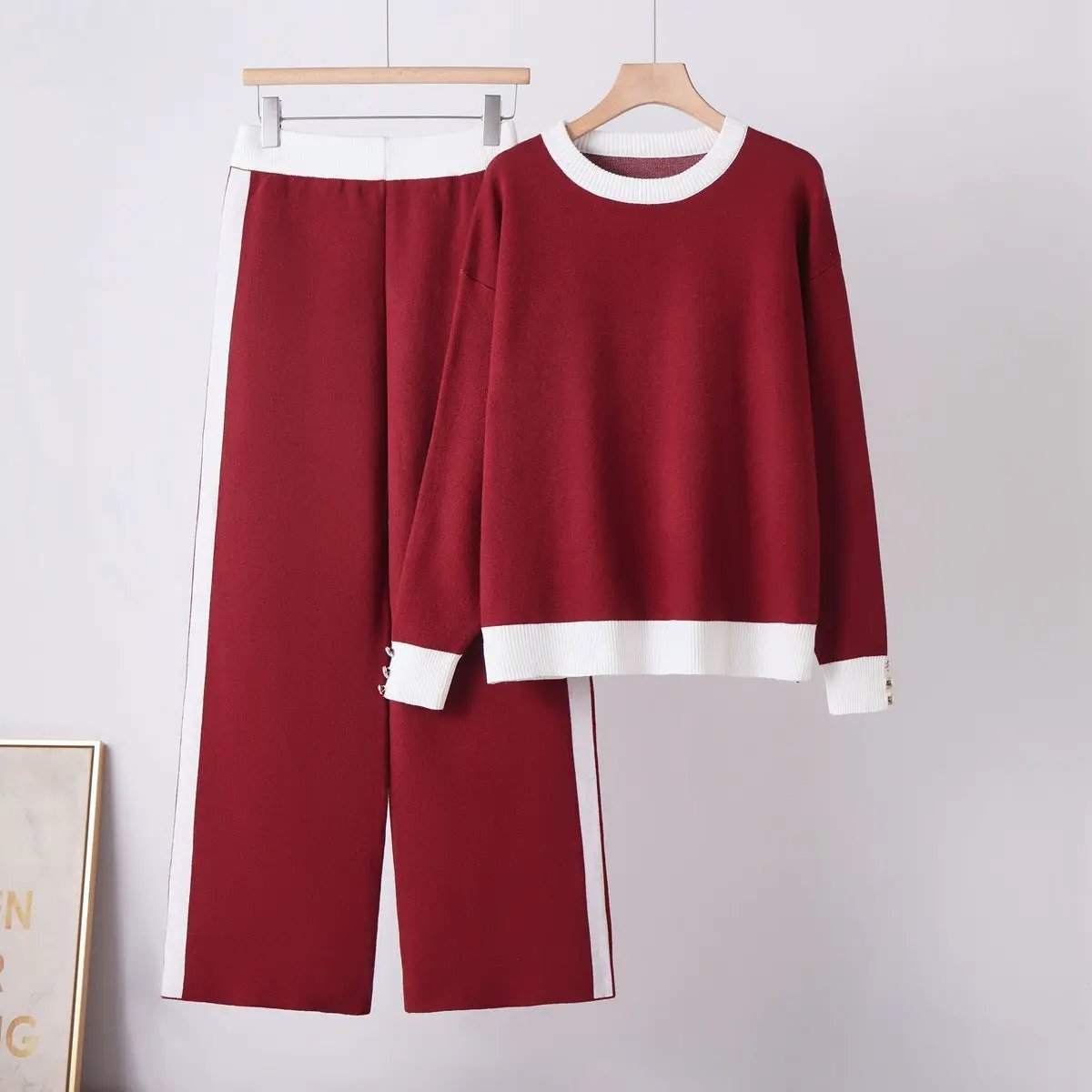 Women's two-piece knit set by eprolo in burgundy with white rib trim; matching sweater and wide-leg pants.
