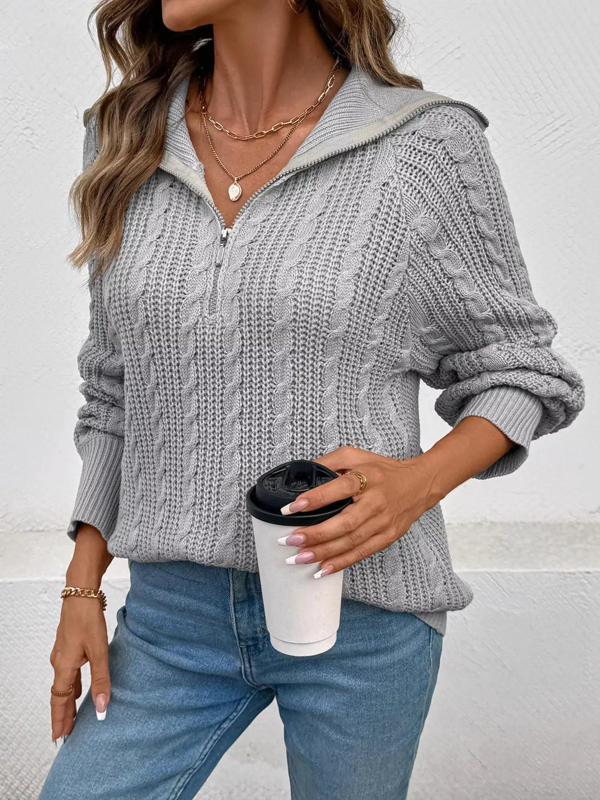 Cable-knit half-zip sweater in gray acrylic; machine washable, paired with blue jeans.