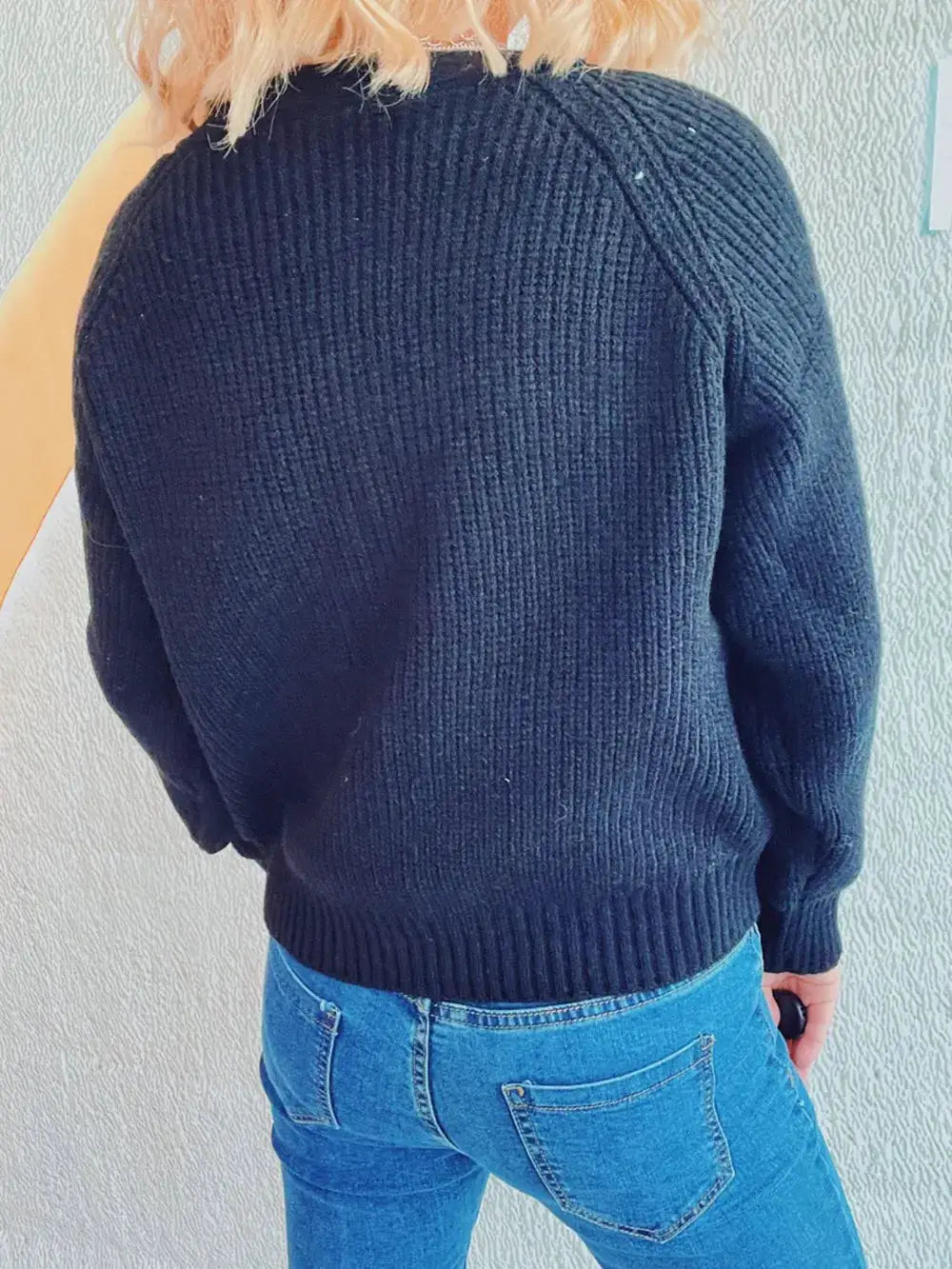 Cardigan, soft navy cable-knit with long sleeves and ribbed hem, back view.