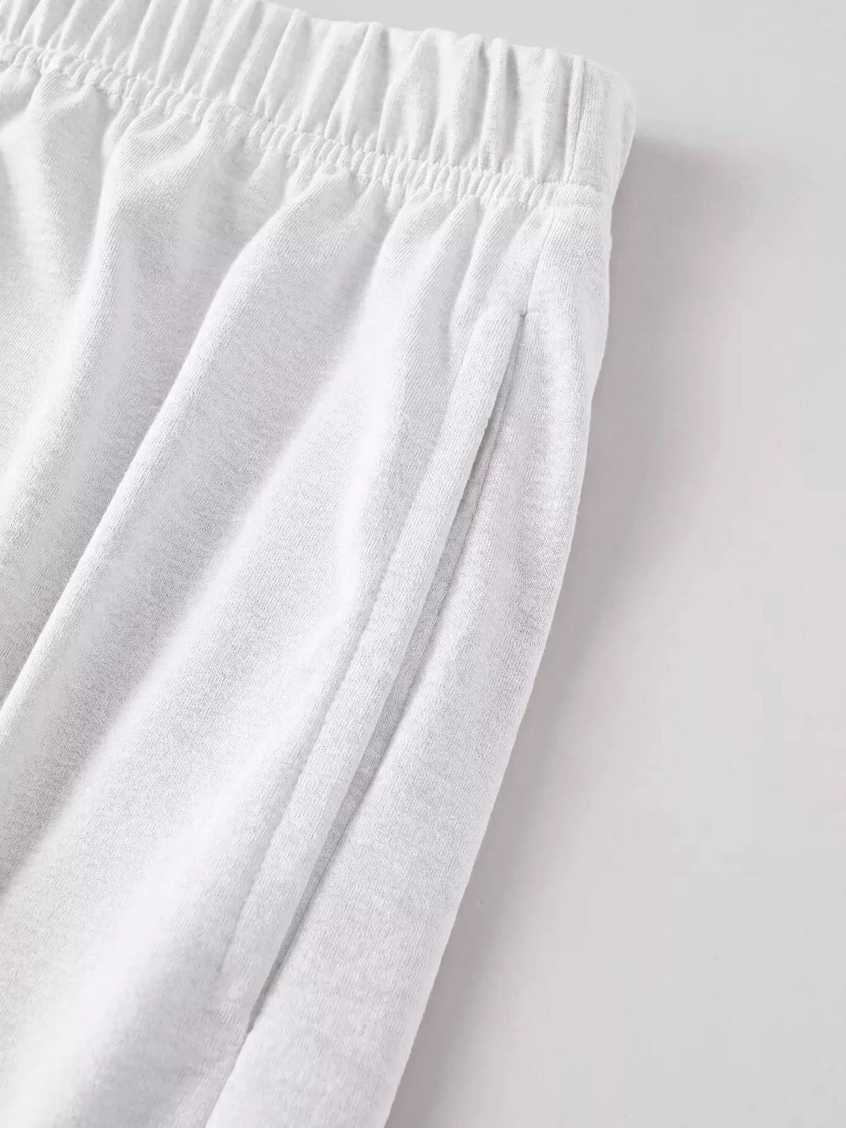 Mens casual polo and relaxed-fit shorts set in white; close-up of elastic waistband fabric