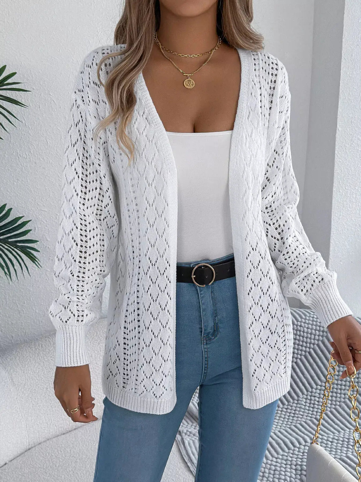 Openwork long-sleeve cardigan in white, open-front knit worn over a white tank with blue jeans