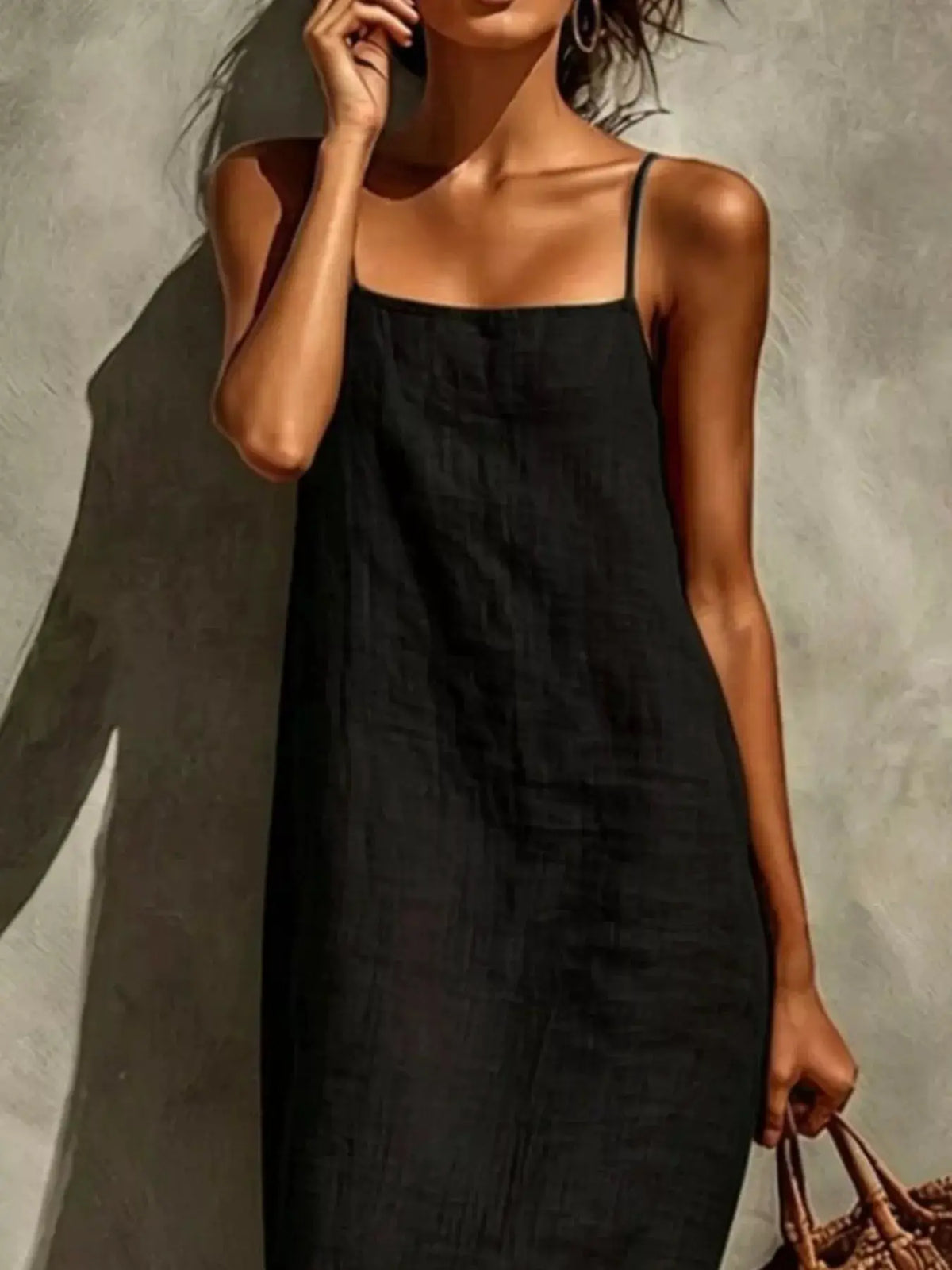 Sleeveless linen maxi dress in black with delicate spaghetti straps and a relaxed fit.
