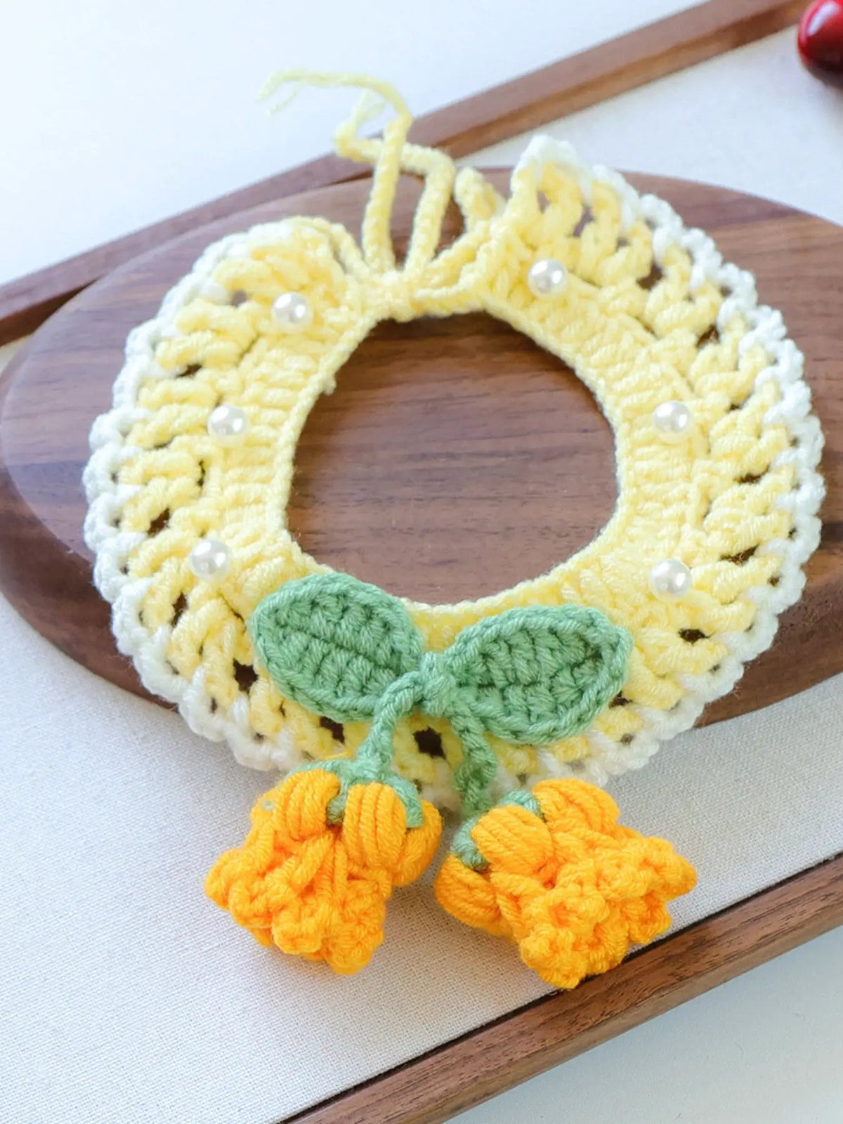 Contrast Pet Scarf with yellow crochet collar, white edging, green leaves, orange tassels, and pearl beads.