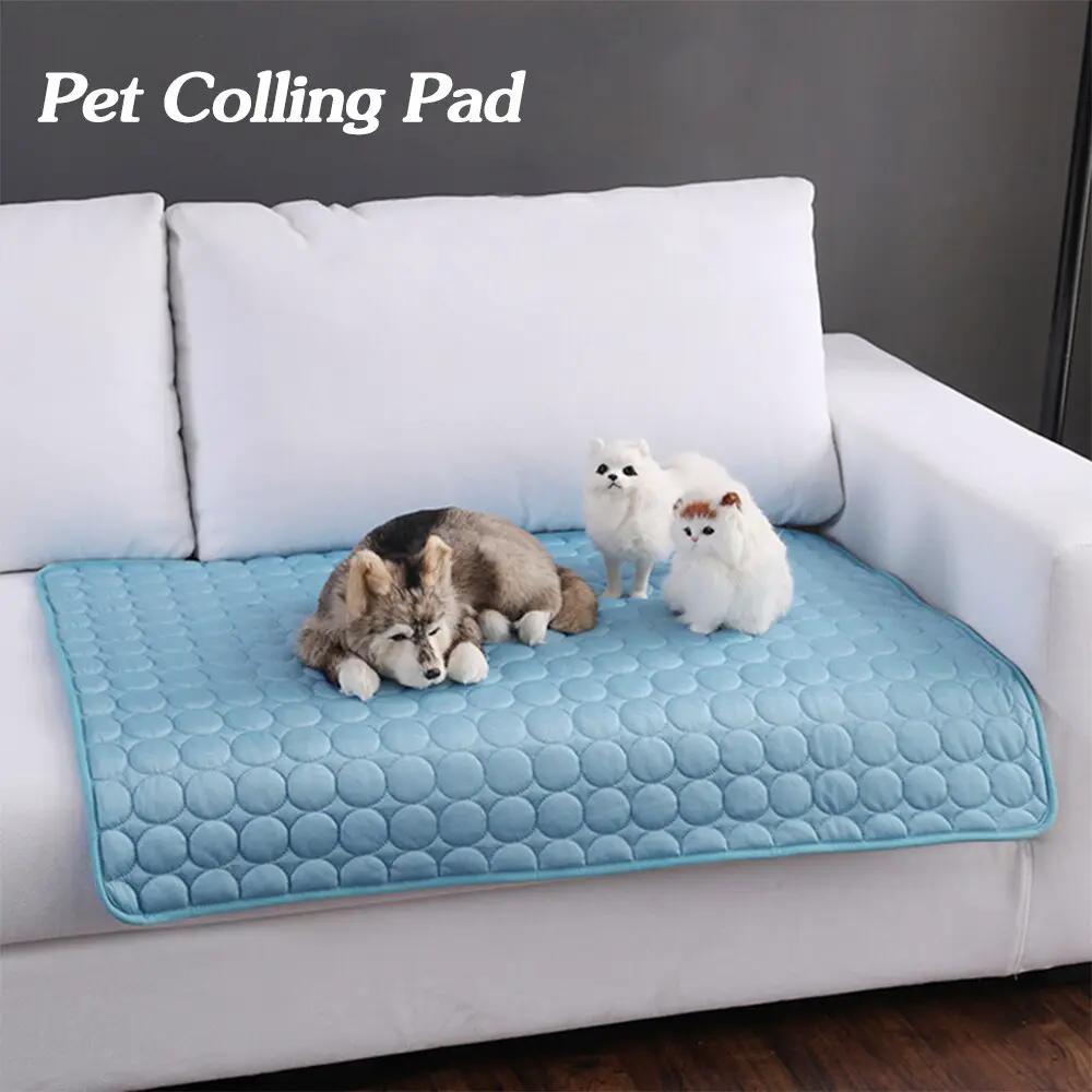 Pet cooling pad in blue ice-silk quilted nest on sofa; a dog and two fluffy white cats sit on it