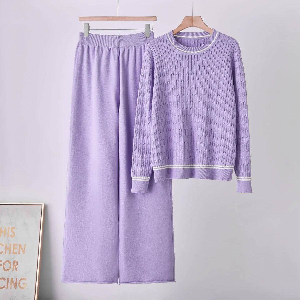 Two-piece lavender cable-knit sweater set with round neckline and matching pants.