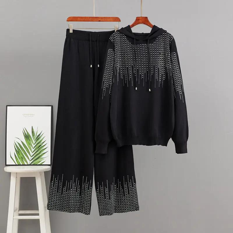 Oversized black knit sweater set by eprolo with hood, high neck, and beaded fringe; matching wide-leg pants