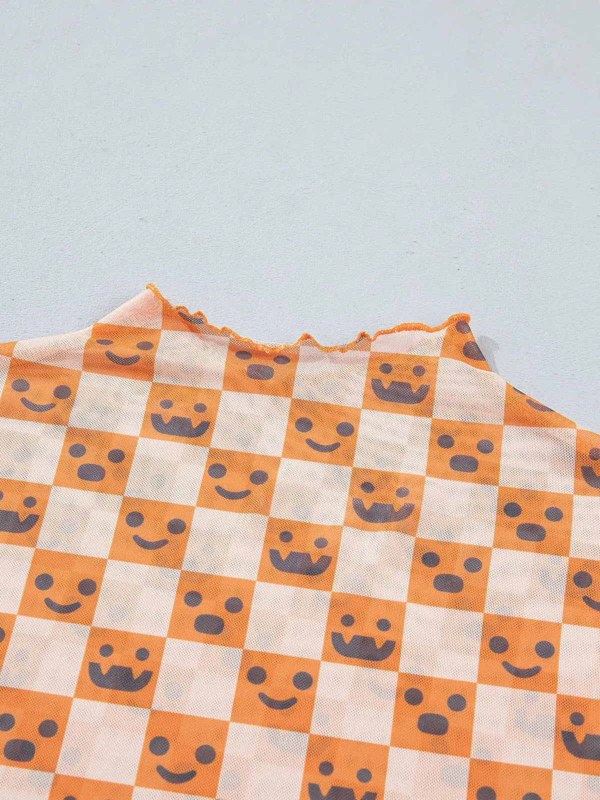 Trendsi abstract Halloween-pattern long-sleeve mock-neck blouse in orange-and-white checkerboard with cute faces