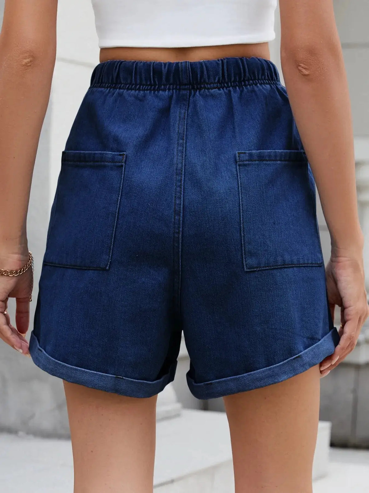 Soft washed drawstring shorts for women in blue denim with back pockets, elastic waistband, and rolled cuffs