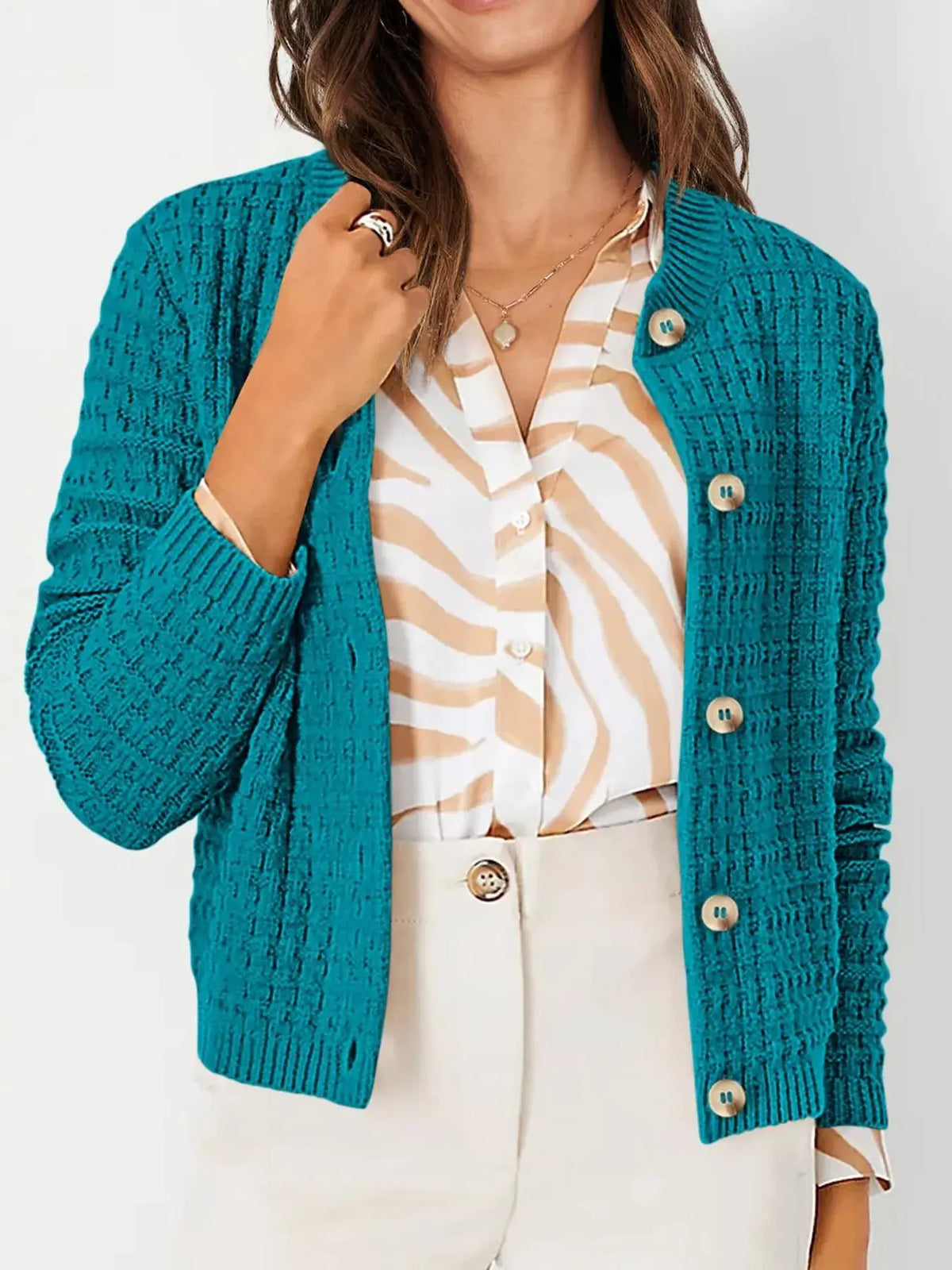 Textured teal knit cardigan with button-front and beige buttons, layered over a beige striped blouse.