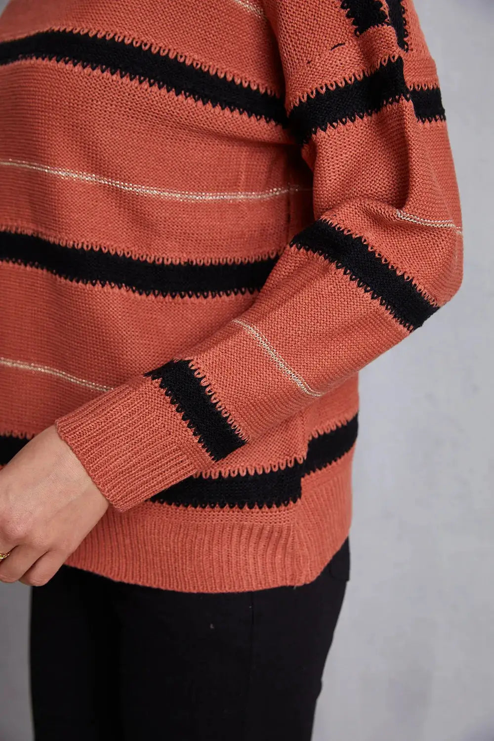 Relaxed round-neck dropped-shoulder striped knit sweater in coral with bold black stripes and a subtle cream stripe