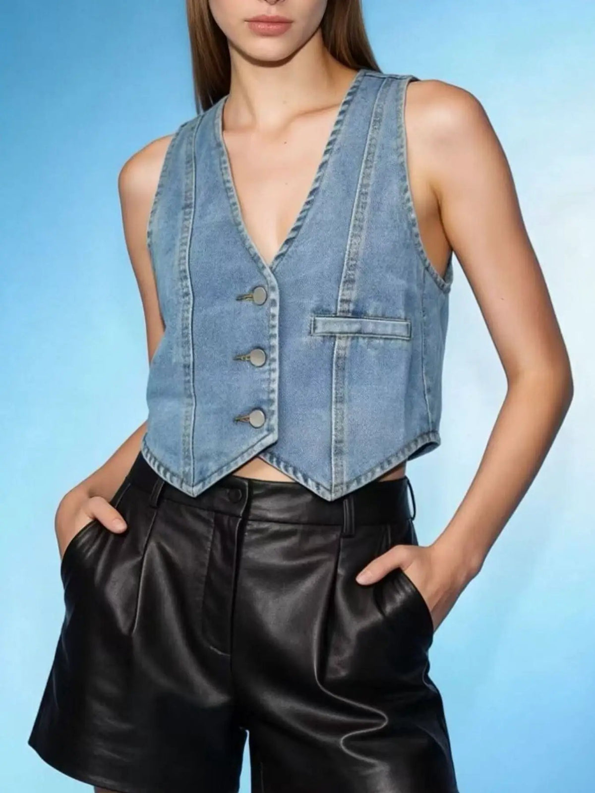 Unlined denim vest; light-wash sleeveless button-down with front placket and chest pocket.