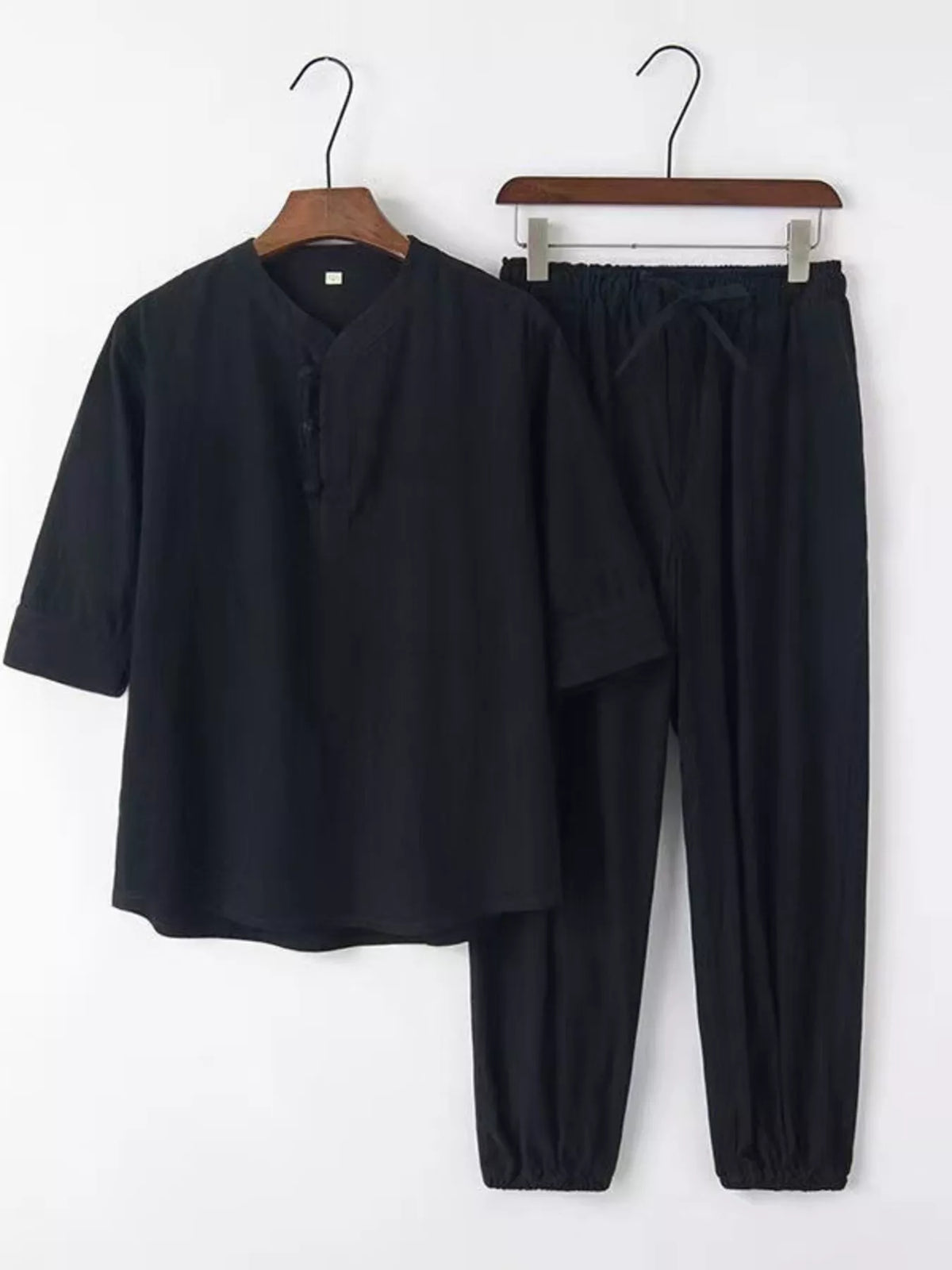 Men's plus-size 3/4 sleeve top and pants set in black; lightweight fabric with elasticized cuffs for a relaxed look