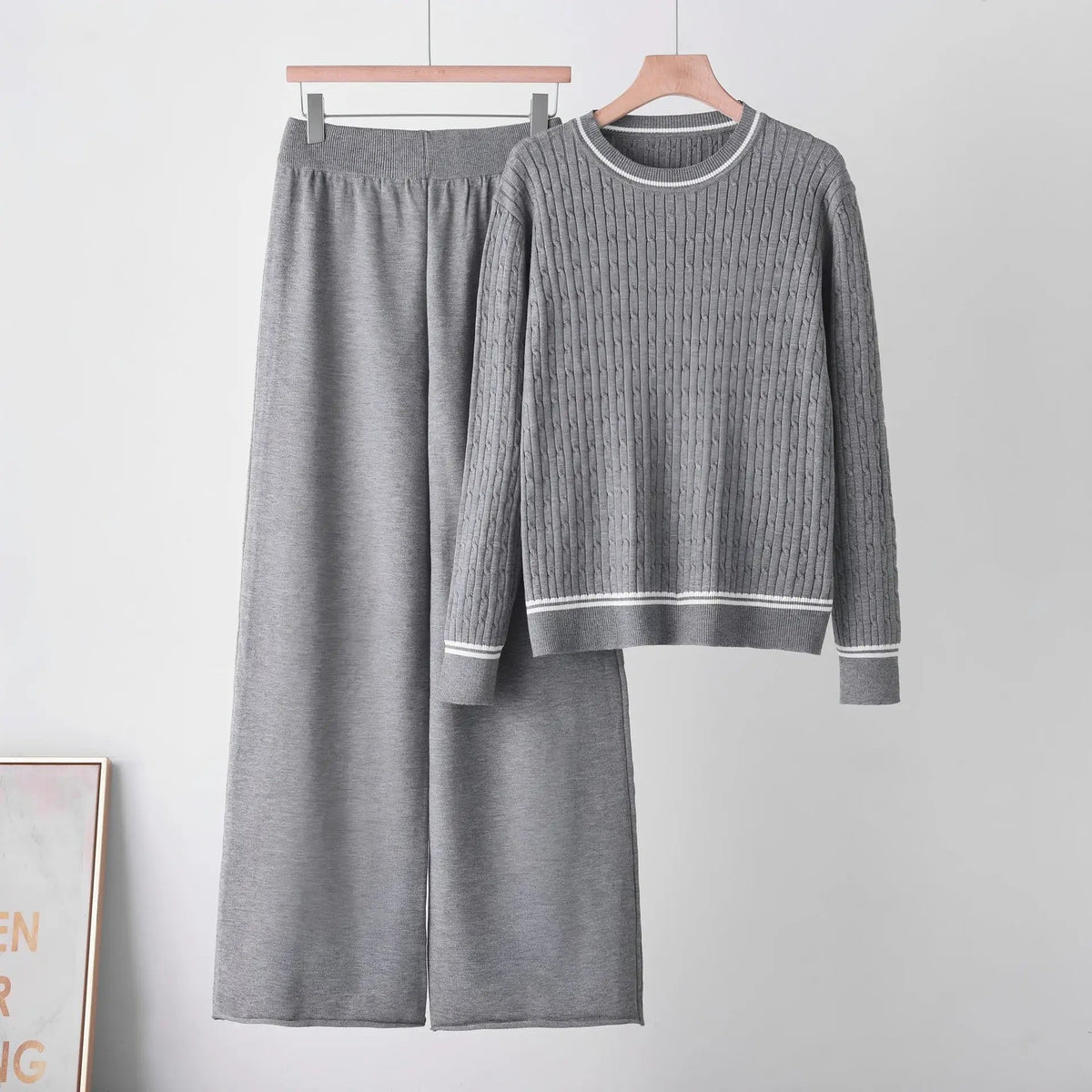 Long sleeve cable-knit two-piece sweater set in gray with round neckline and matching pants.
