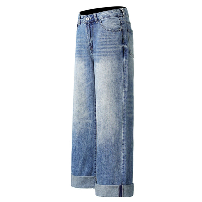 Blue washed denim jeans with faded panels, wide-leg silhouette and rolled cuffs