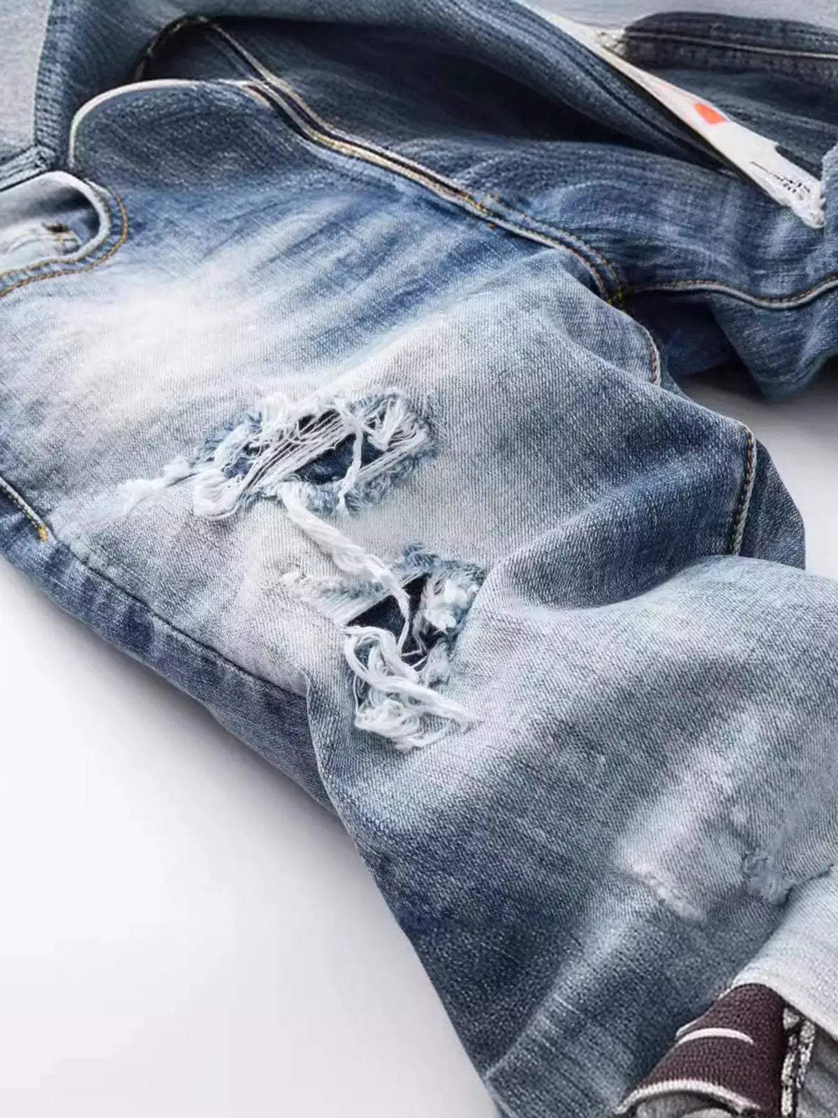 Men's distressed slim-fit blue denim jeans by Trendsi with ripped knee