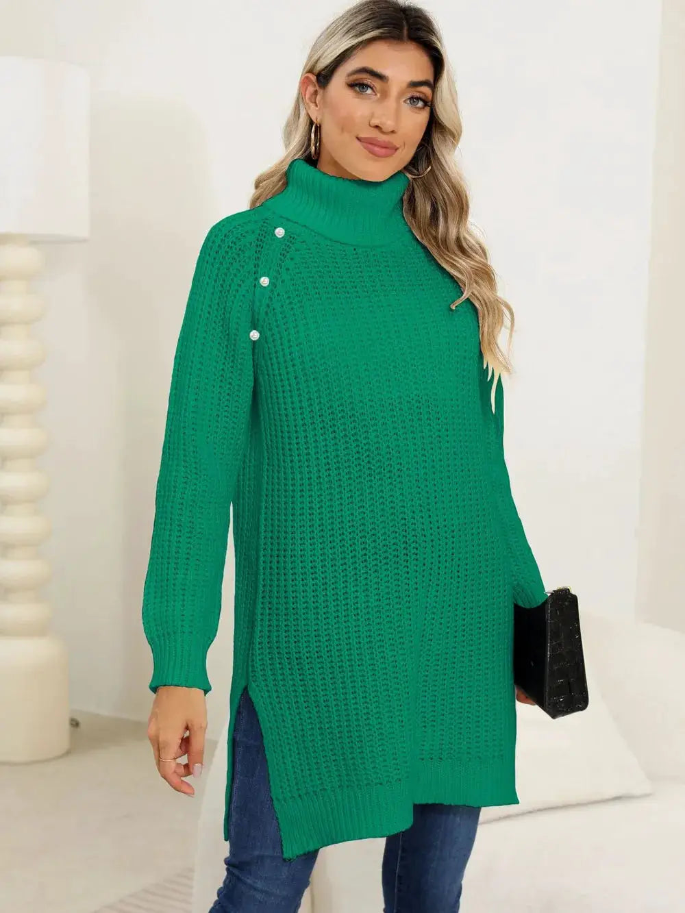 Women's green knit pullover sweater with turtleneck, long sleeves, side slits and pearl-button shoulder accents.