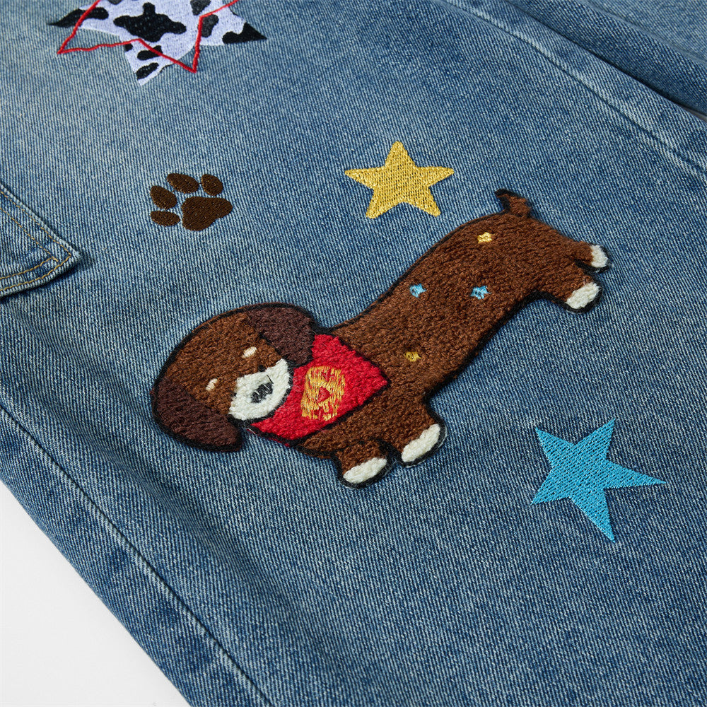 Embroidered denim workwear pants with cartoon dog patch and colorful star decorations on blue jeans