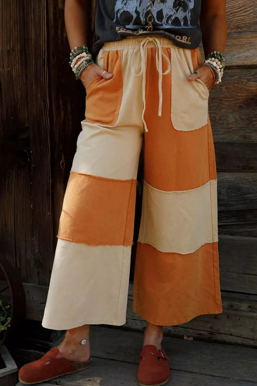 Raw seam colorblock wide-leg ankle-length casual pants in orange and cream.