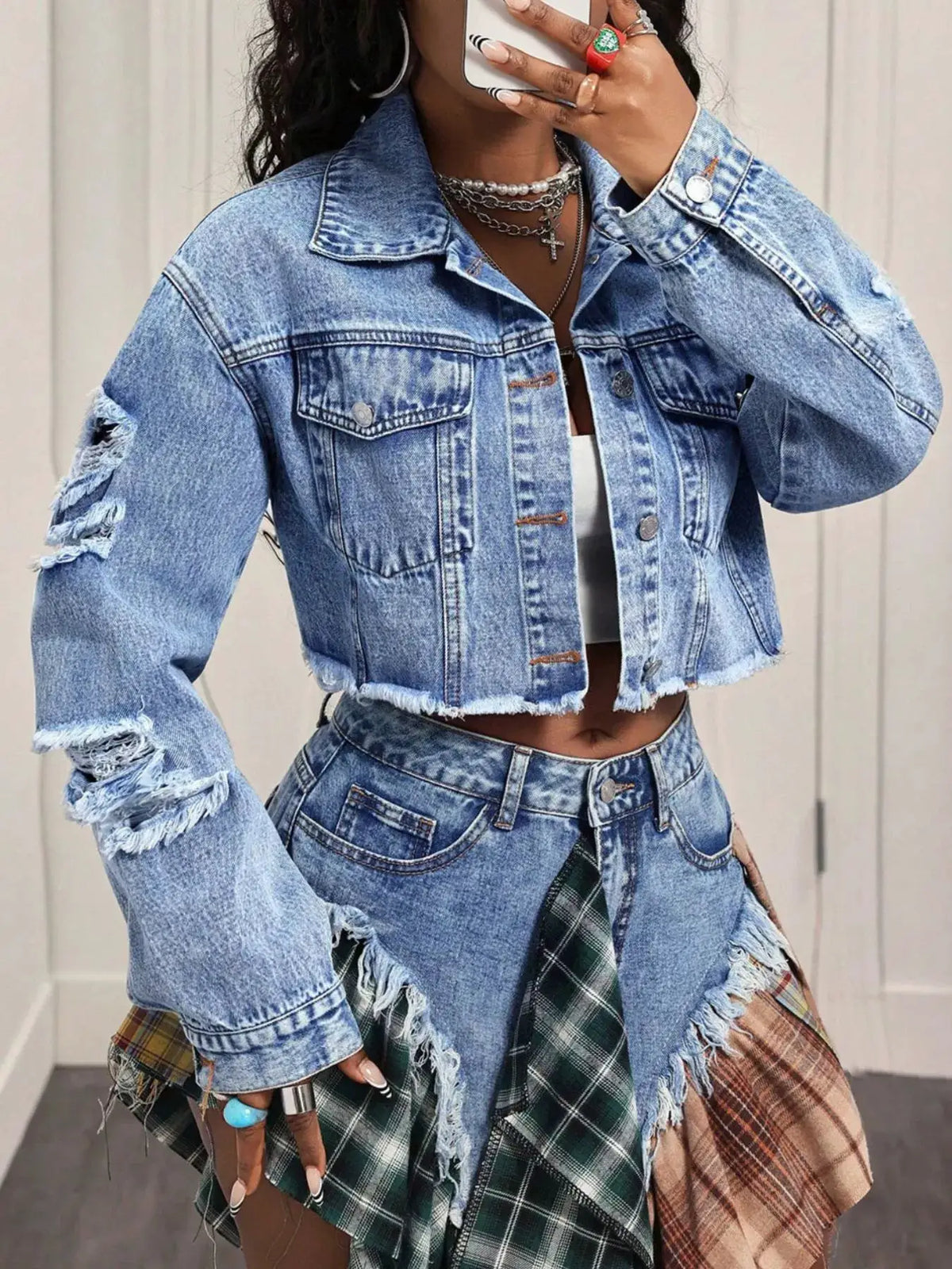 Distressed cropped blue denim jacket with front pockets and frayed hem
