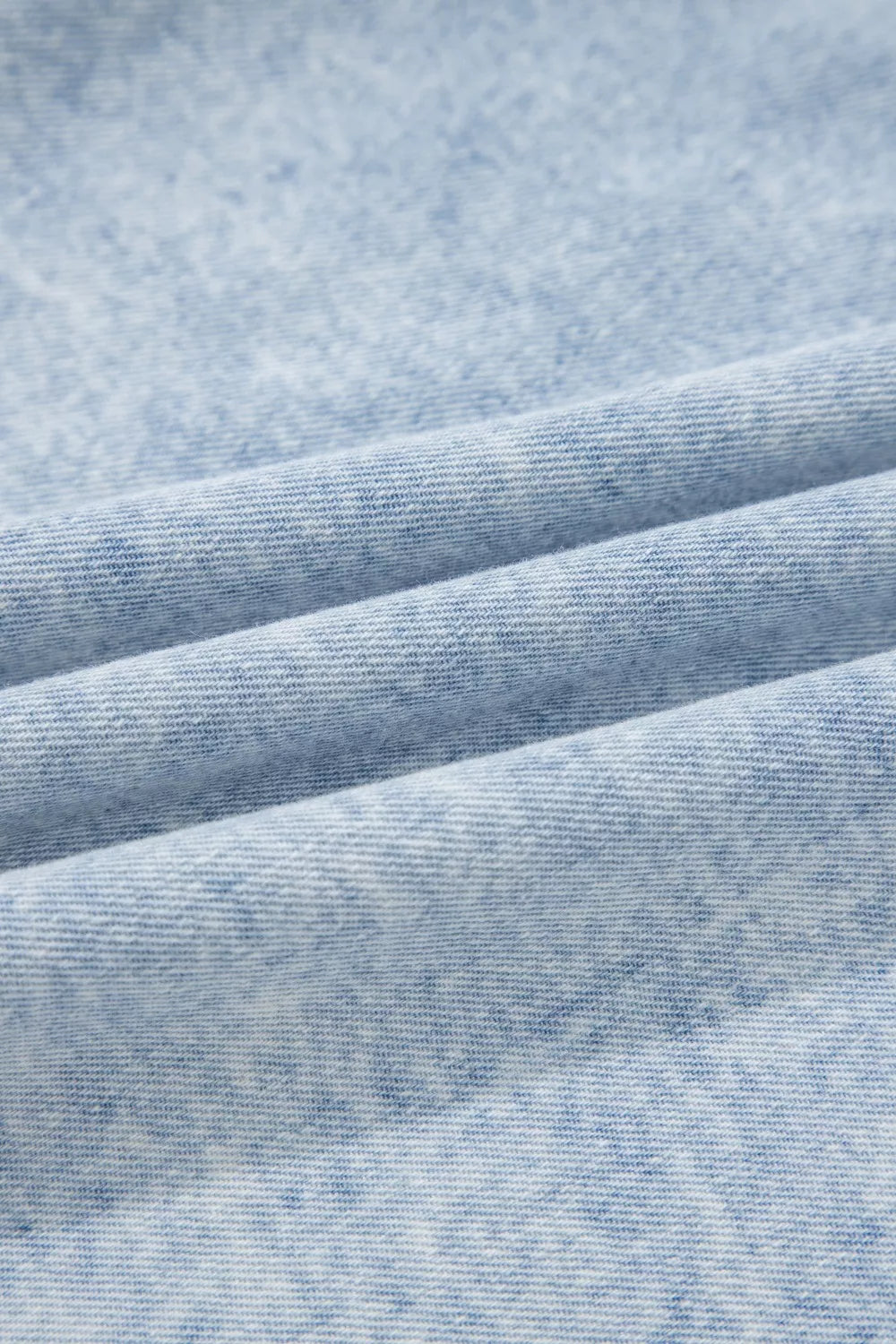 Vintage washed denim fabric close-up in light blue