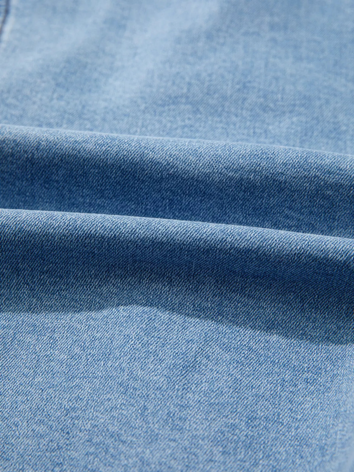 Blue denim fabric close-up with diagonal twill texture