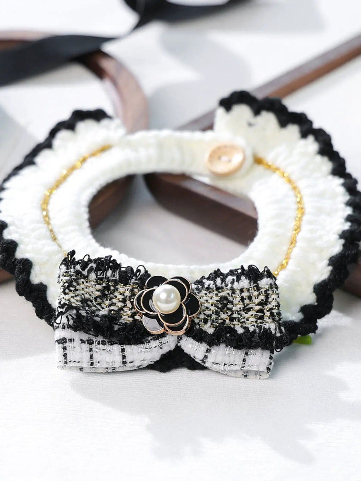 Contrast Pet Scarf, white knit with black scalloped edge, gold chain detail, and pearl flower accent.