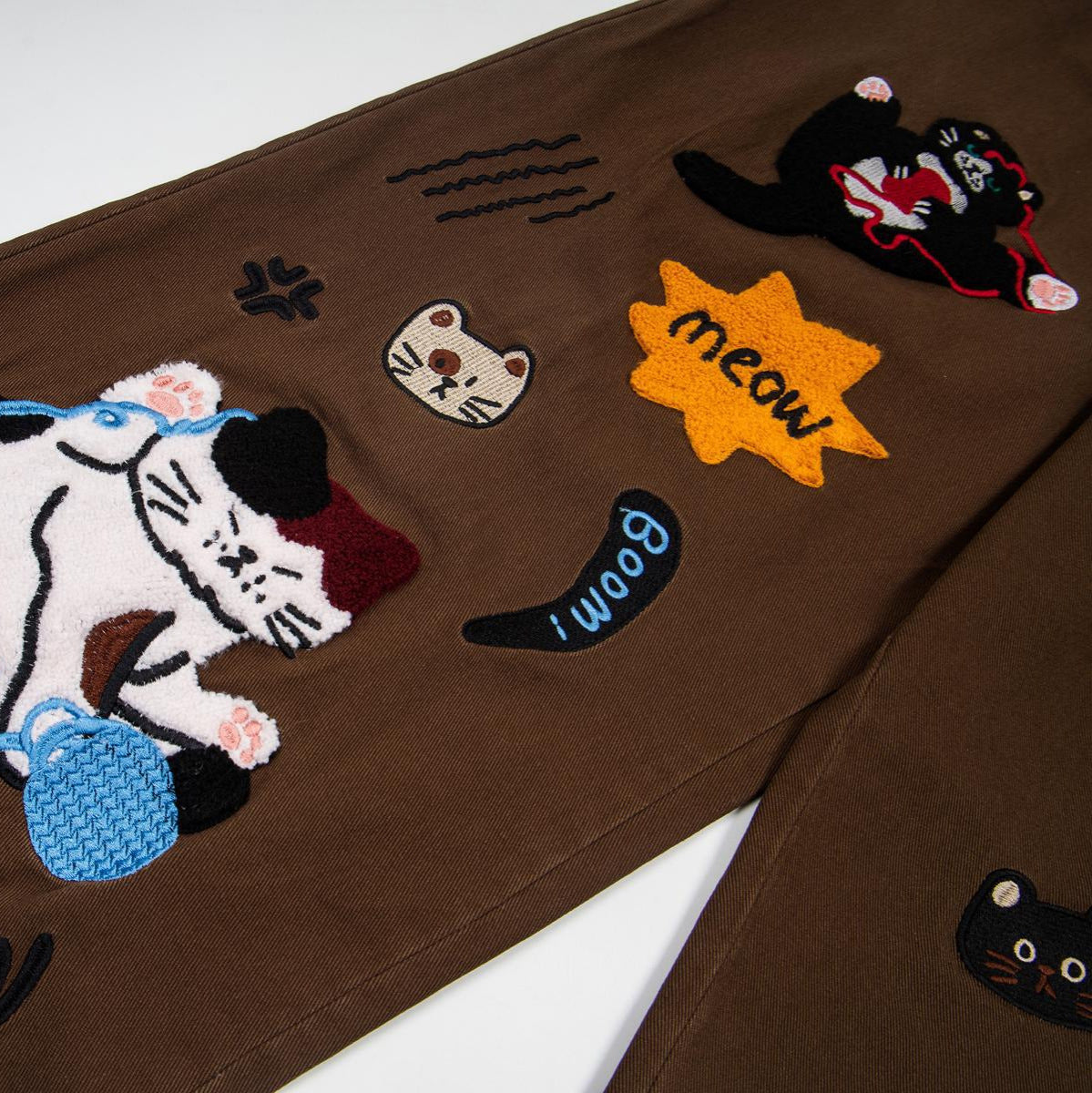Cat embroidered jeans; brown denim with several cat patches and meow text, street fashion by eprolo.