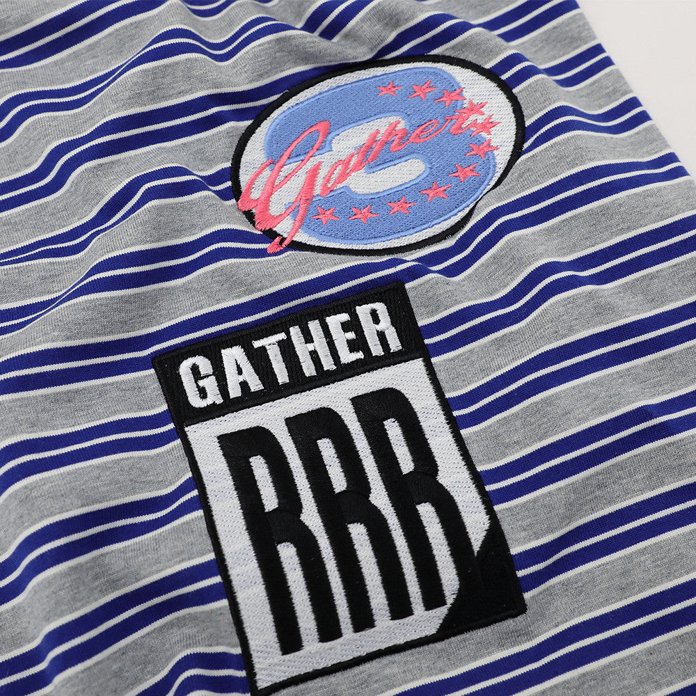 Striped gray and blue short-sleeve polo shirt with circular patch and bold rectangular patch.