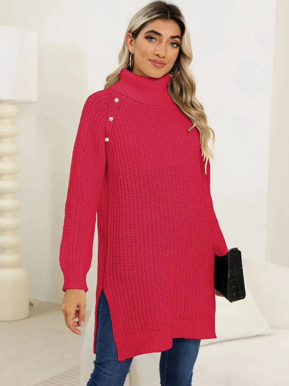 Pink knit turtleneck pullover with side slits and pearl button shoulder detail