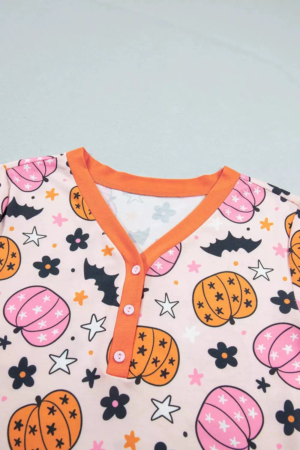 Halloween pumpkin-print long-sleeve lounge set with orange trim on pink background