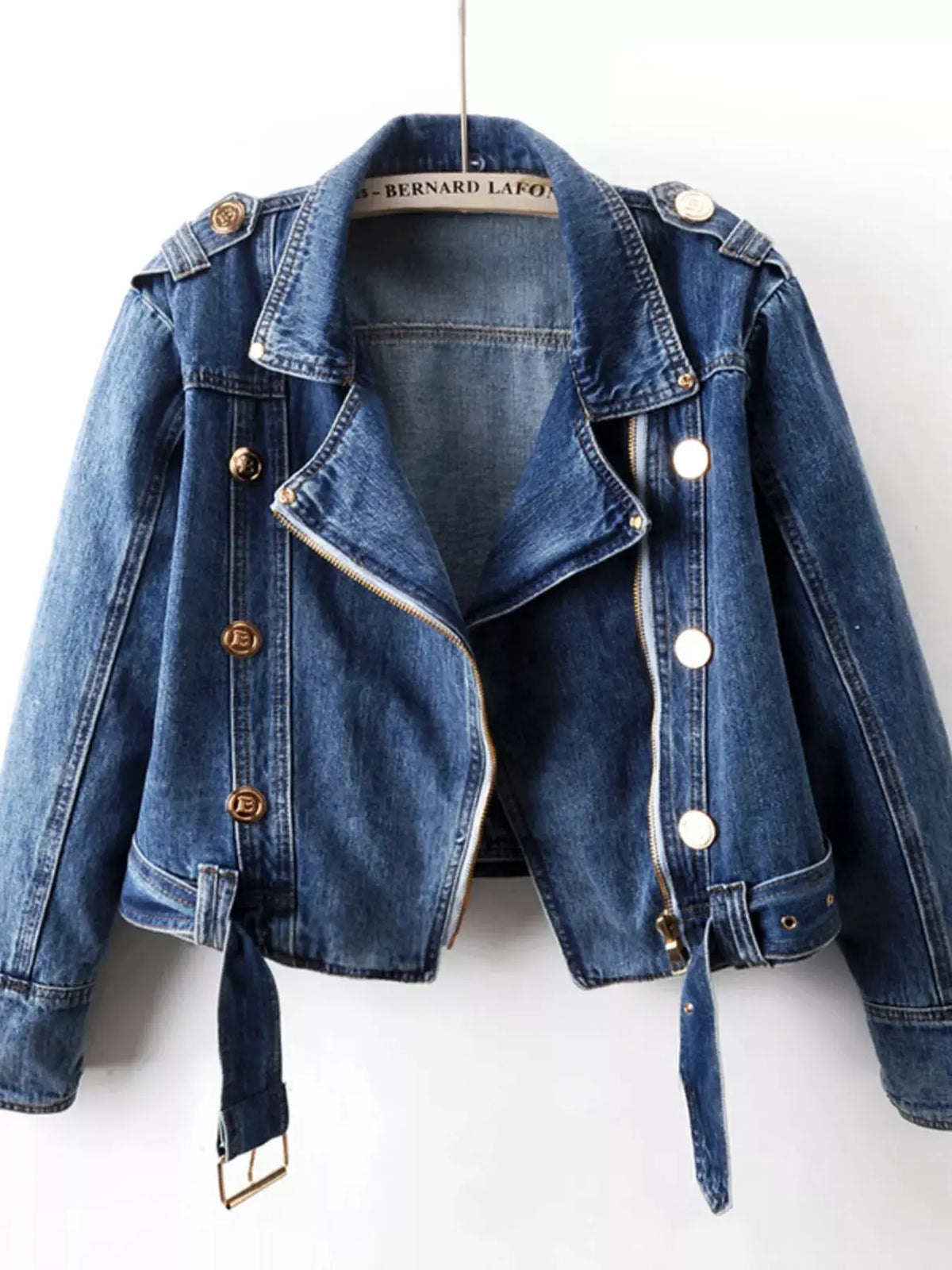 Asymmetrical zip-front denim jacket with belted waist, blue wash and gold hardware.